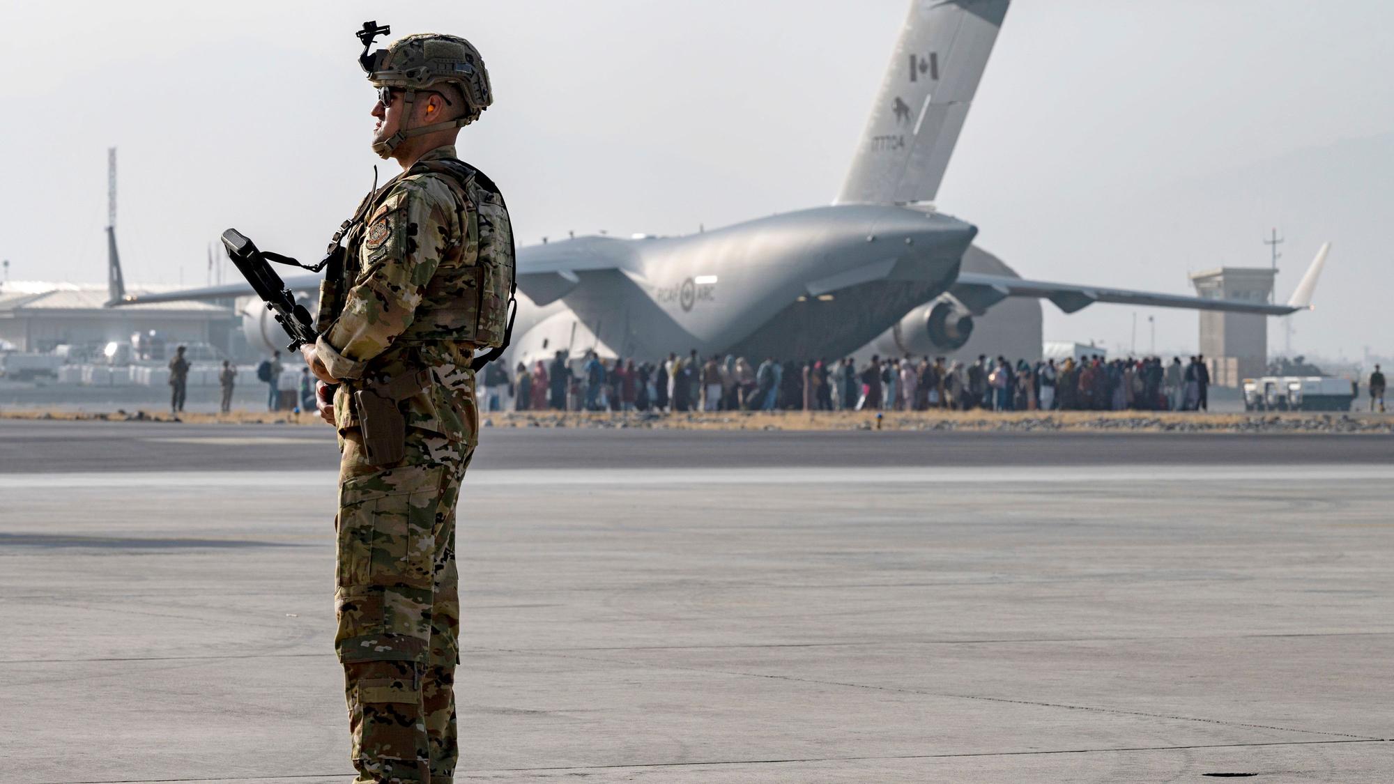Ein US-Soldat der US-Luftwaffe bewacht die Evakuierung von Nichtkombattanten mit einem Flugzeug vom Typ C-17 Globemaster III auf dem Hamid Karzai International Airport.
