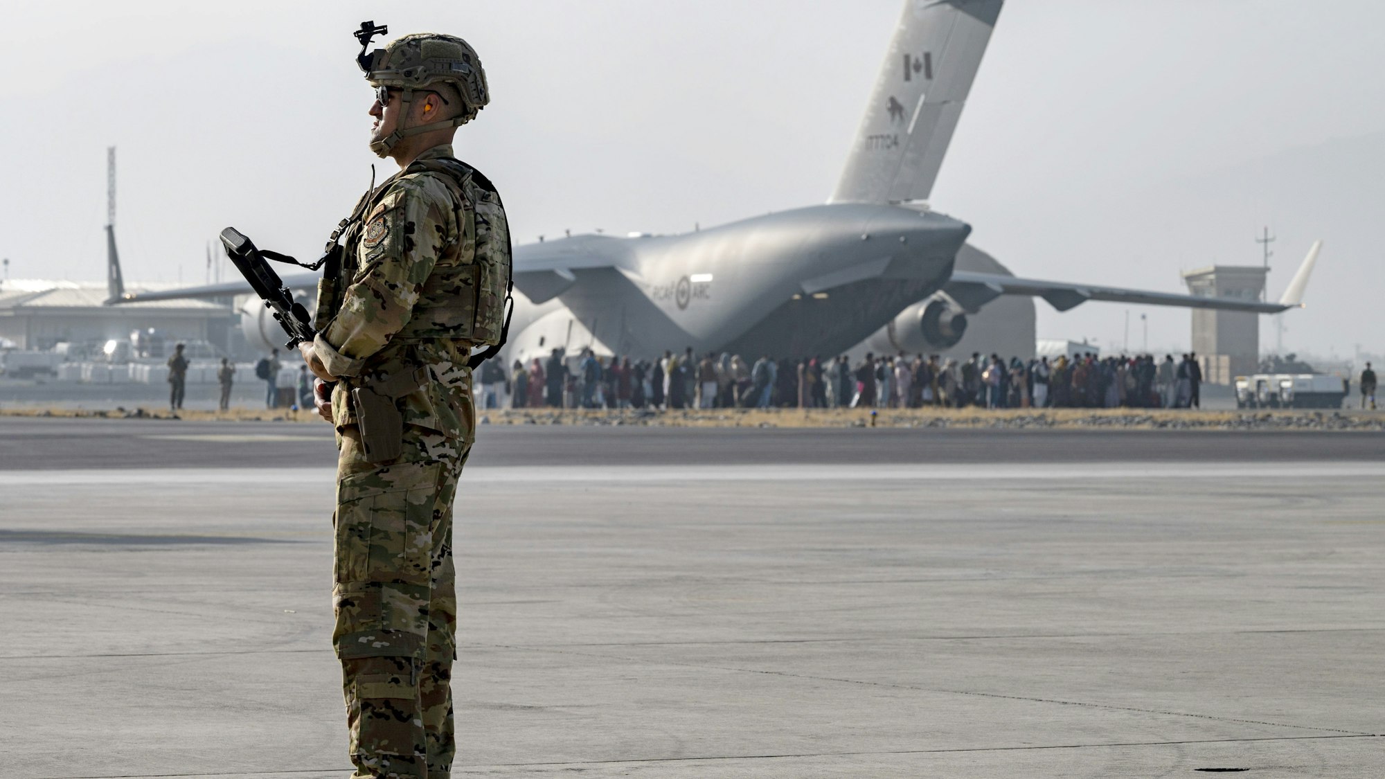 Ein US-Soldat der US-Luftwaffe bewacht die Evakuierung von Nichtkombattanten mit einem Flugzeug vom Typ C-17 Globemaster III auf dem Hamid Karzai International Airport.