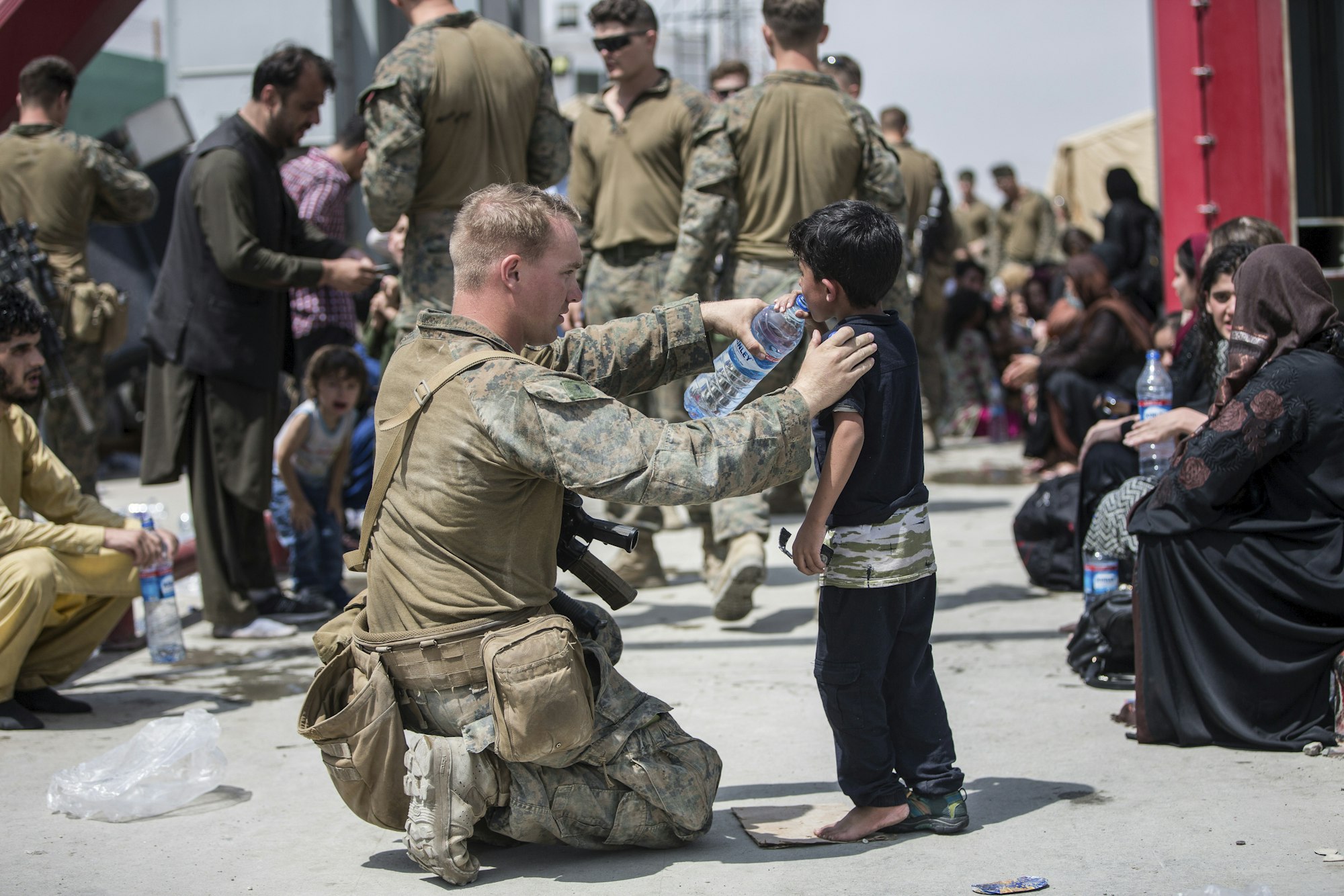 In diesem vom US Marine Corps zur Verfügung gestellten Foto versorgt ein US-Marine ein Kind mit frischem Wasser während einer Evakuierung am Hamid Karzai International Airport.