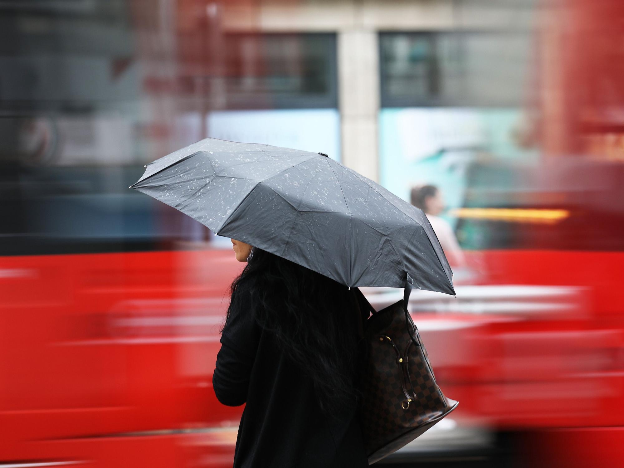 Eine Frau steht am Morgen (4. Juni 2020) mit einem Regenschirm an einer Straßenbahnhaltestelle. Regen bestimmt kurz vor dem Wochenende das Wetter in Nordrhein-Westfalen.
