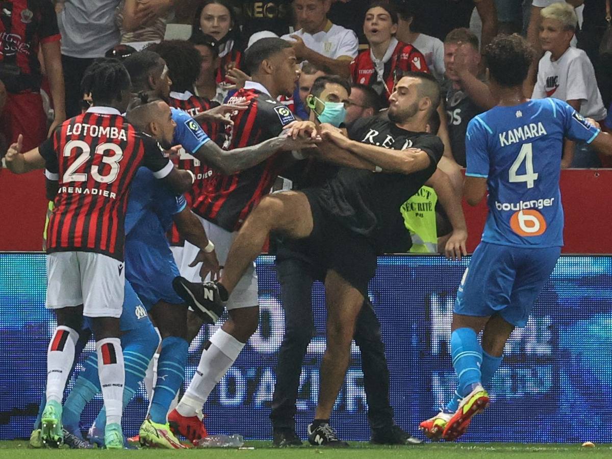 Spieler von Nizza und Marseille versuchen einen Fan am Platzsturm zu hindern.