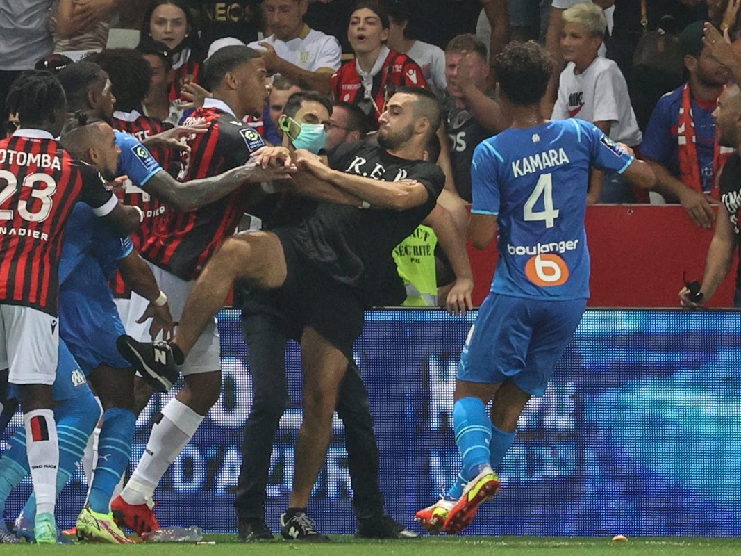 Spieler von Nizza und Marseille versuchen einen Fan am Platzsturm zu hindern.