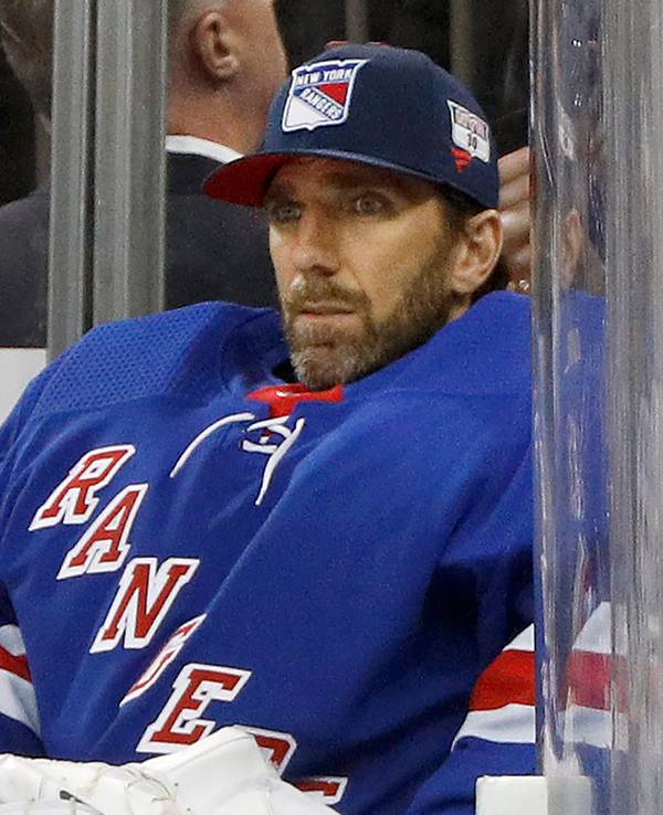 Henrik Lundqvist sitzt bei einem Eishockey-Spiel auf der Ersatzbank.