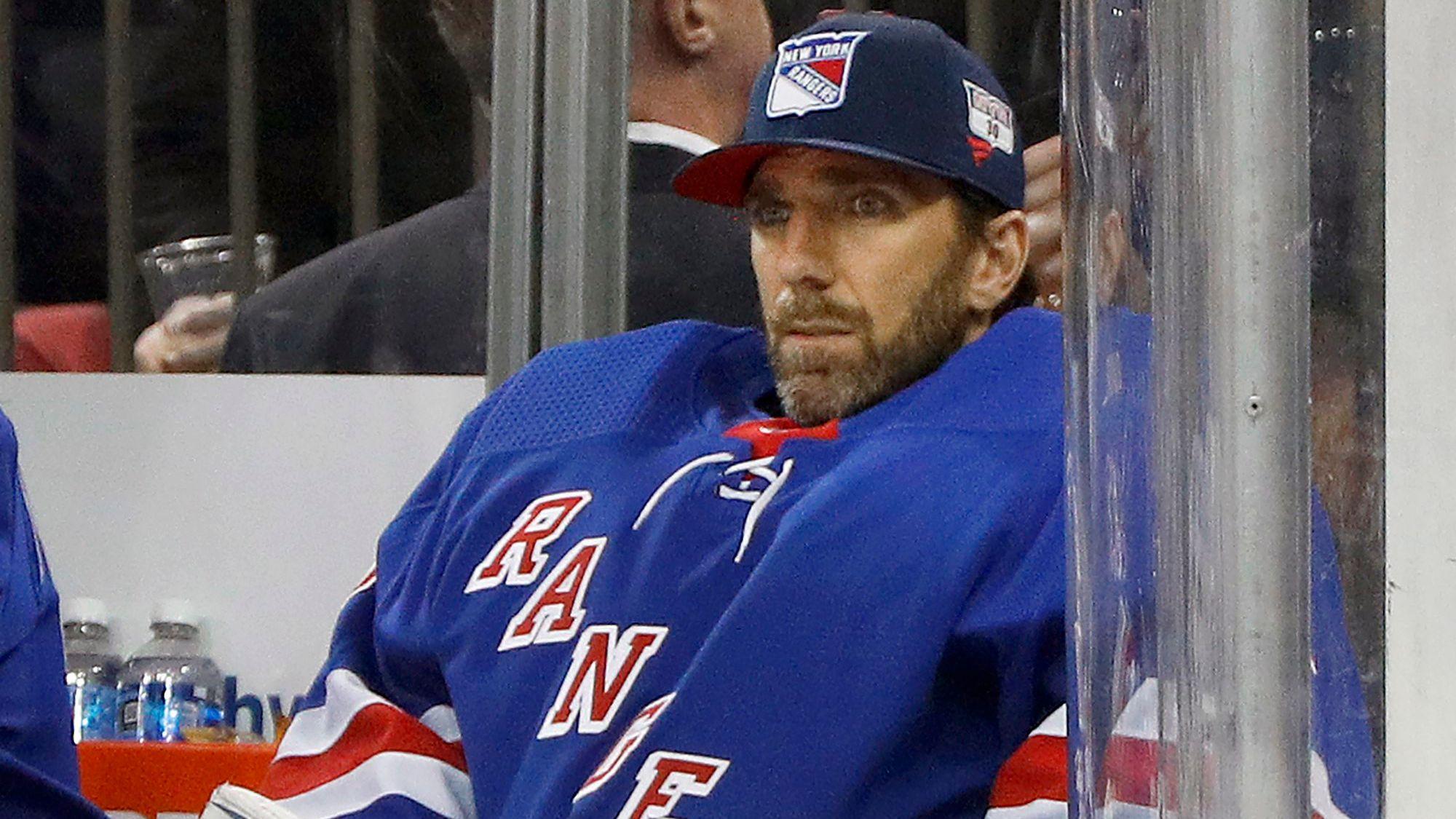 Henrik Lundqvist sitzt bei einem Eishockey-Spiel auf der Ersatzbank.