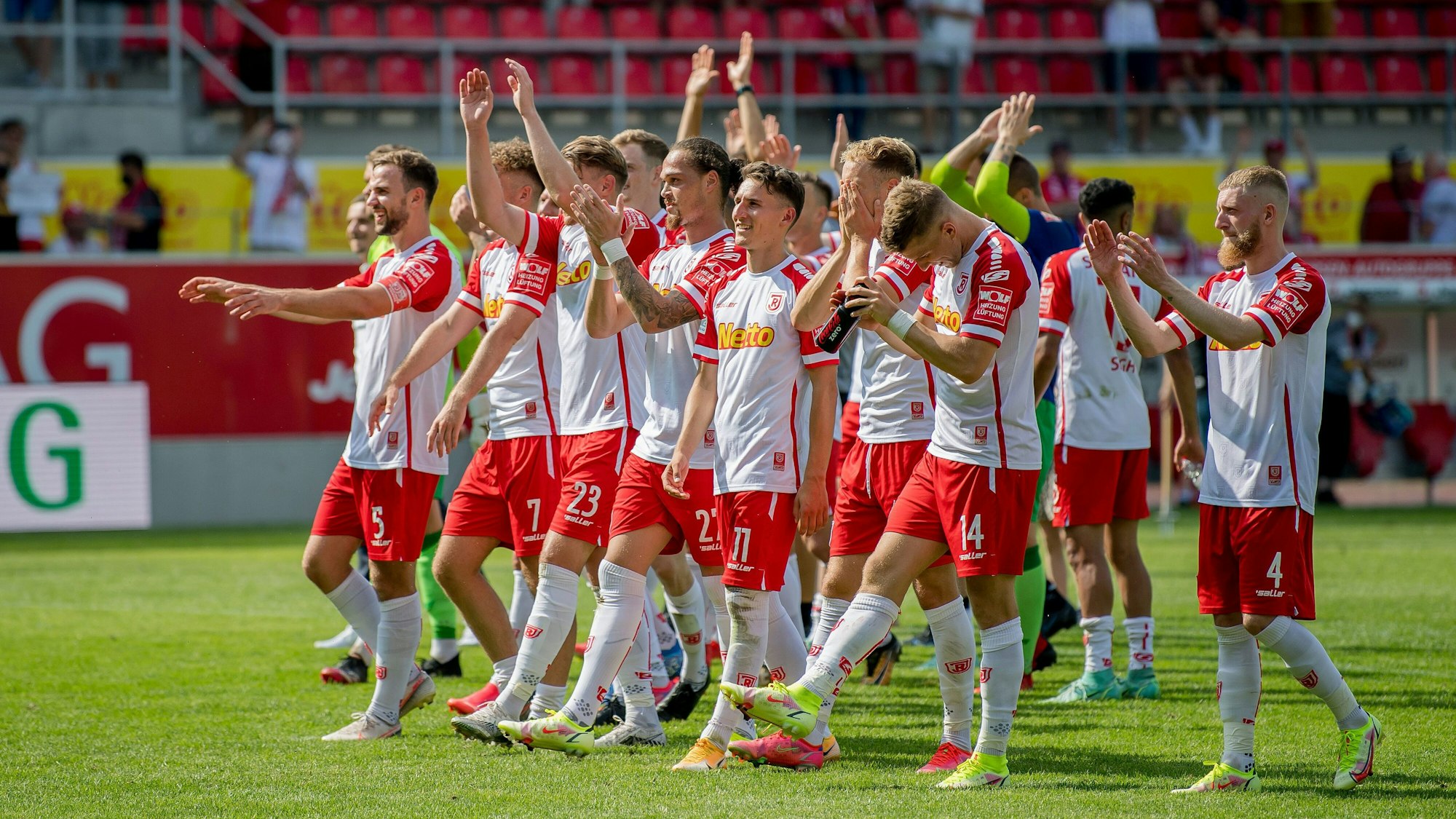 Die Spieler von Jahn Regensburg jubeln ihren Fans zu.