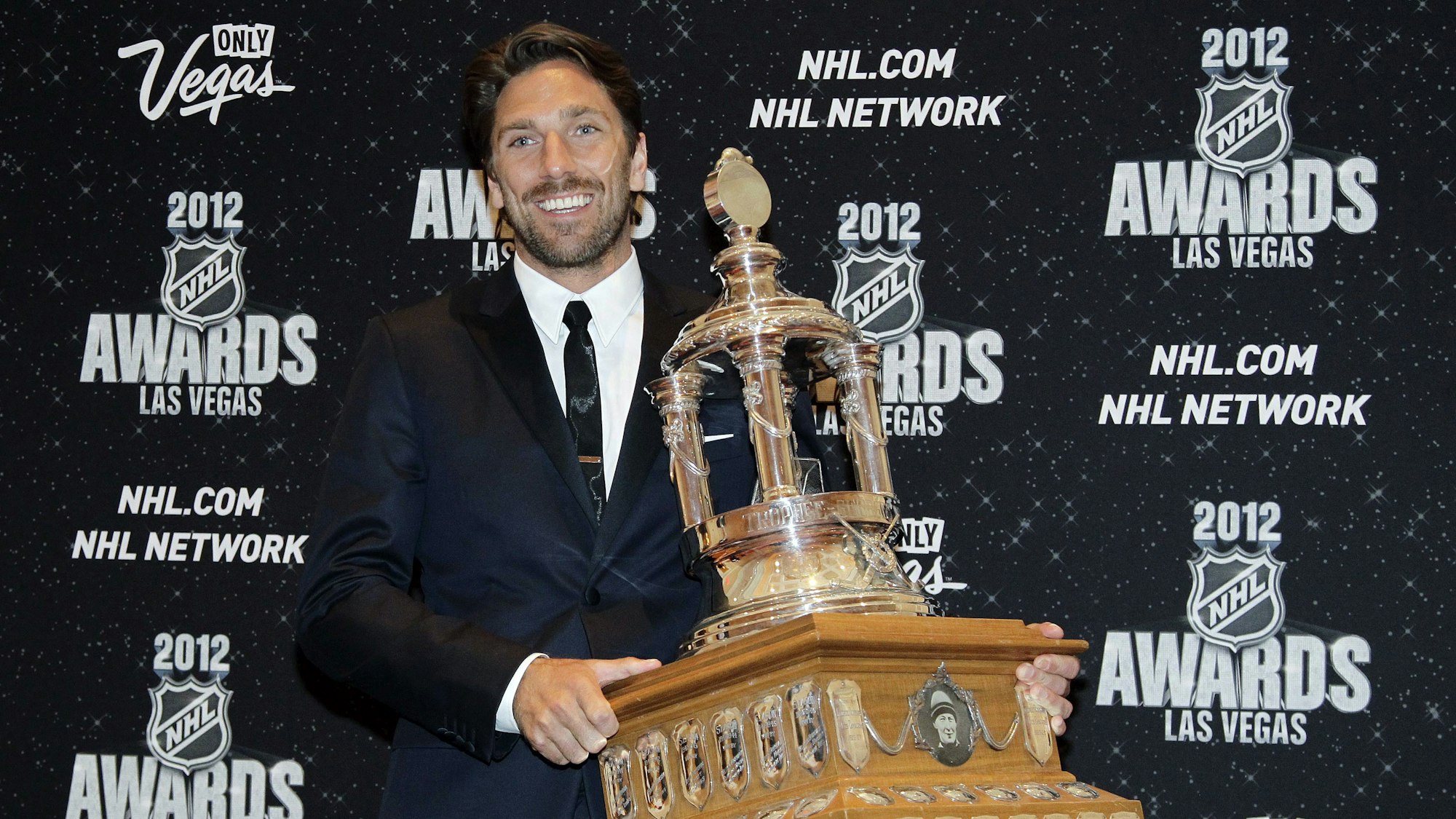 Henrik Lundqvist posiert mit der Vezina Trophy für den besten Keeper der NHL.