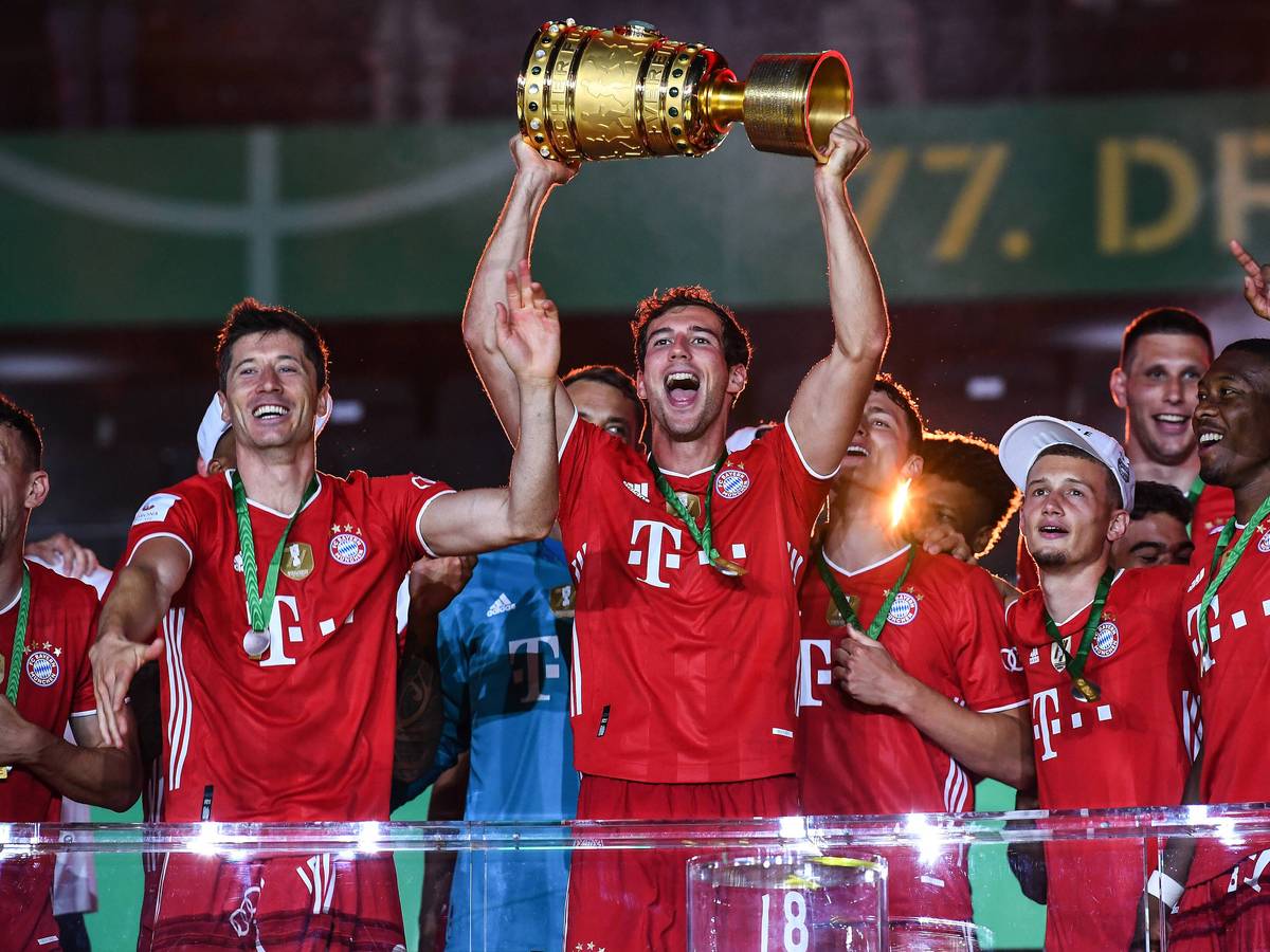 Leon Goretzka hält den DFB-Pokal mit seinen Händen in den Nachthimmel, neben ihm feiert Robert Lewandowski.