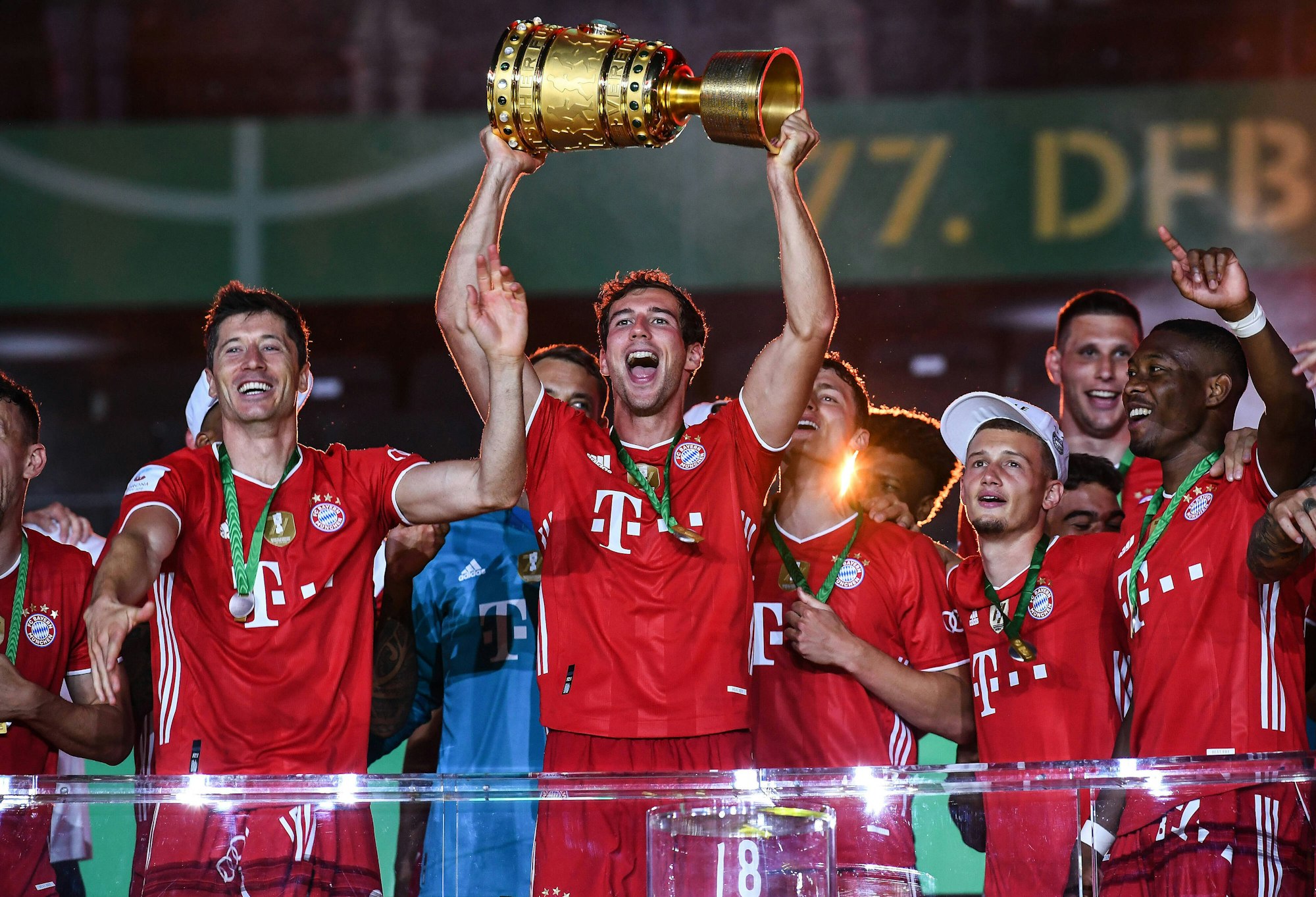 Leon Goretzka hält den DFB-Pokal mit seinen Händen in den Nachthimmel, neben ihm feiert Robert Lewandowski.