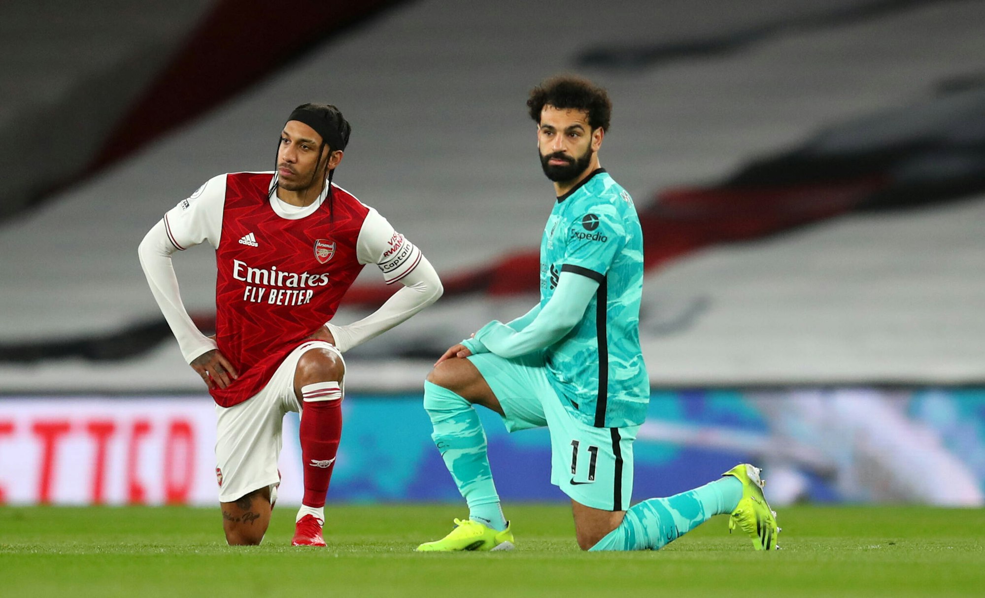 Mo Salah und Pierre-Emerick Aubameyang knien nebeneinander nieder.