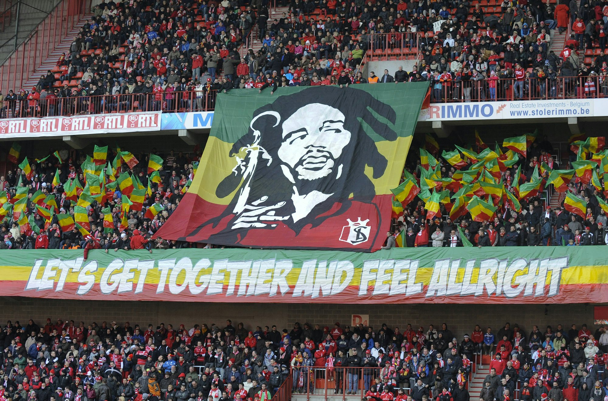 Fans von Standard Lüttich schwenken rot-gelb-grüne Fähnchen und zeigen ein Konterfei von Bob Marley im Trikot des Vereins.