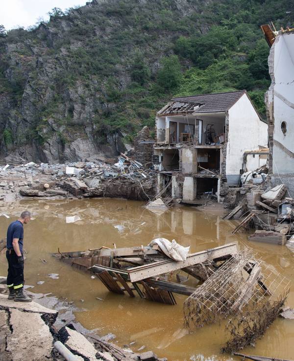 Ein Feuerwehrmann steht im Dorf Mayschoß vor einem völlig zerstörten Haus. Der Klimawandel erhöht laut einer Studie die Wahrscheinlichkeit extremer Regenfälle und damit von Hochwasserkatastrophen, wie sie im Juli in Rheinland-Pfalz und Nordrhein-Westfalen vielen Menschen das Leben gekostet hat.