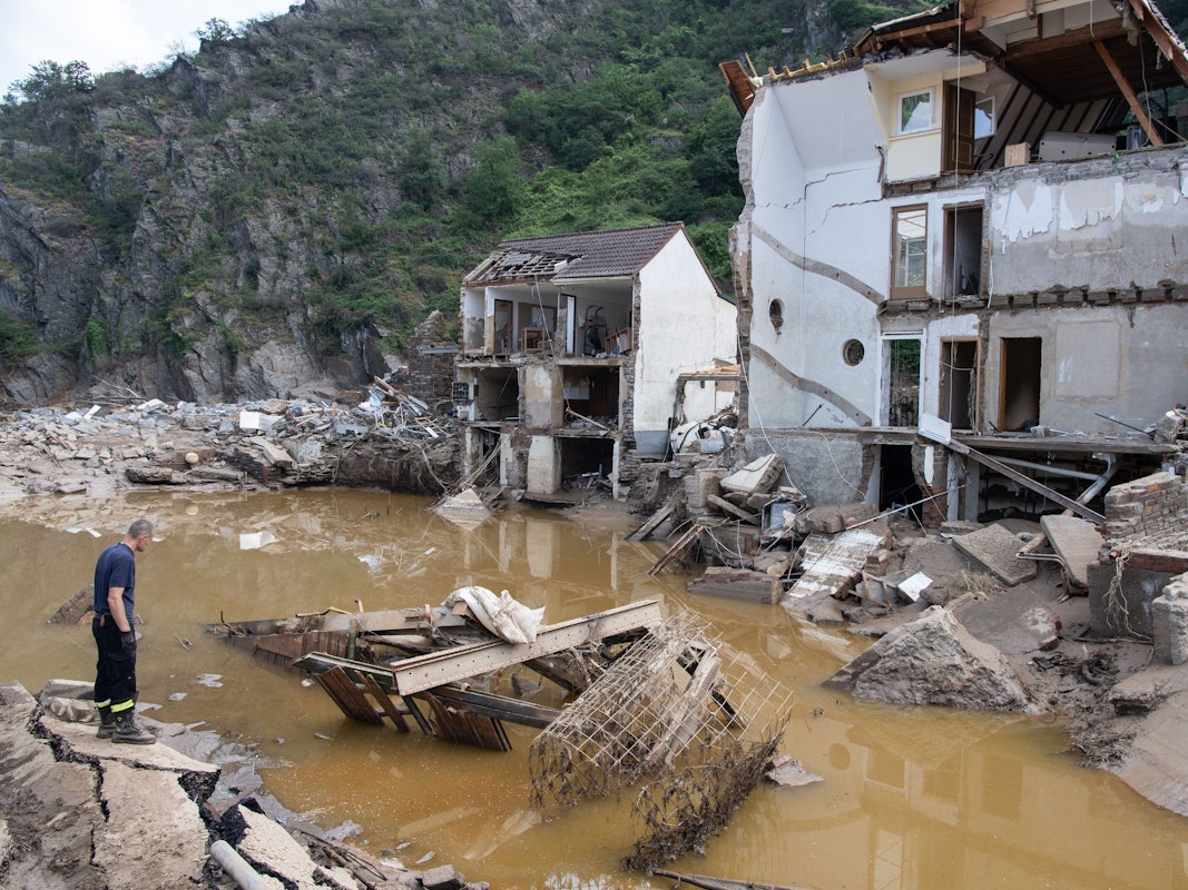 Ein Feuerwehrmann steht im Dorf Mayschoß vor einem völlig zerstörten Haus. Der Klimawandel erhöht laut einer Studie die Wahrscheinlichkeit extremer Regenfälle und damit von Hochwasserkatastrophen, wie sie im Juli in Rheinland-Pfalz und Nordrhein-Westfalen vielen Menschen das Leben gekostet hat.