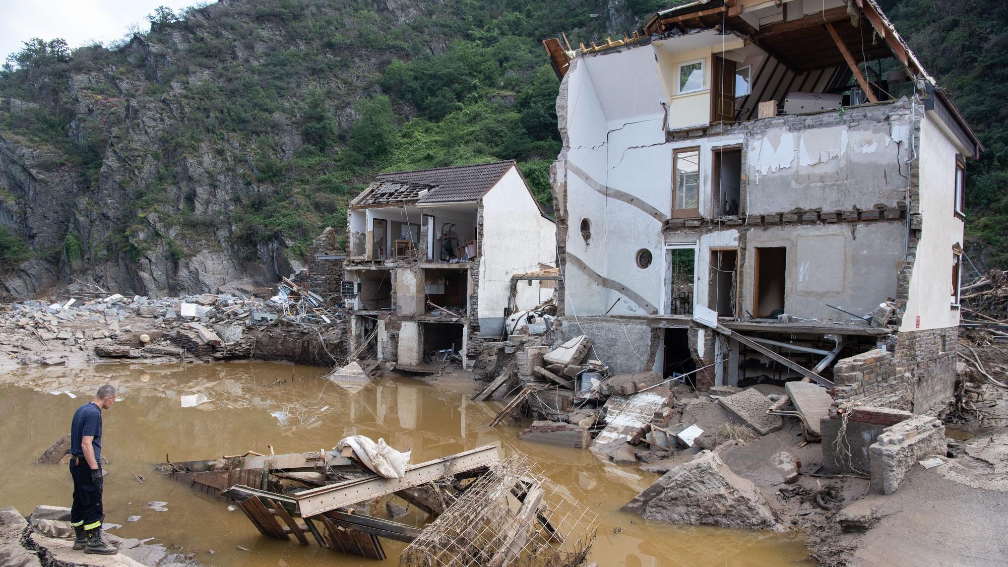 Ein Feuerwehrmann steht im Dorf Mayschoß vor einem völlig zerstörten Haus. Der Klimawandel erhöht laut einer Studie die Wahrscheinlichkeit extremer Regenfälle und damit von Hochwasserkatastrophen, wie sie im Juli in Rheinland-Pfalz und Nordrhein-Westfalen vielen Menschen das Leben gekostet hat.