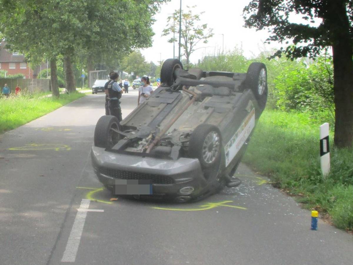 Ein Auto hat sich auf einer Straße überschlagen und liegt auf dem Dach.