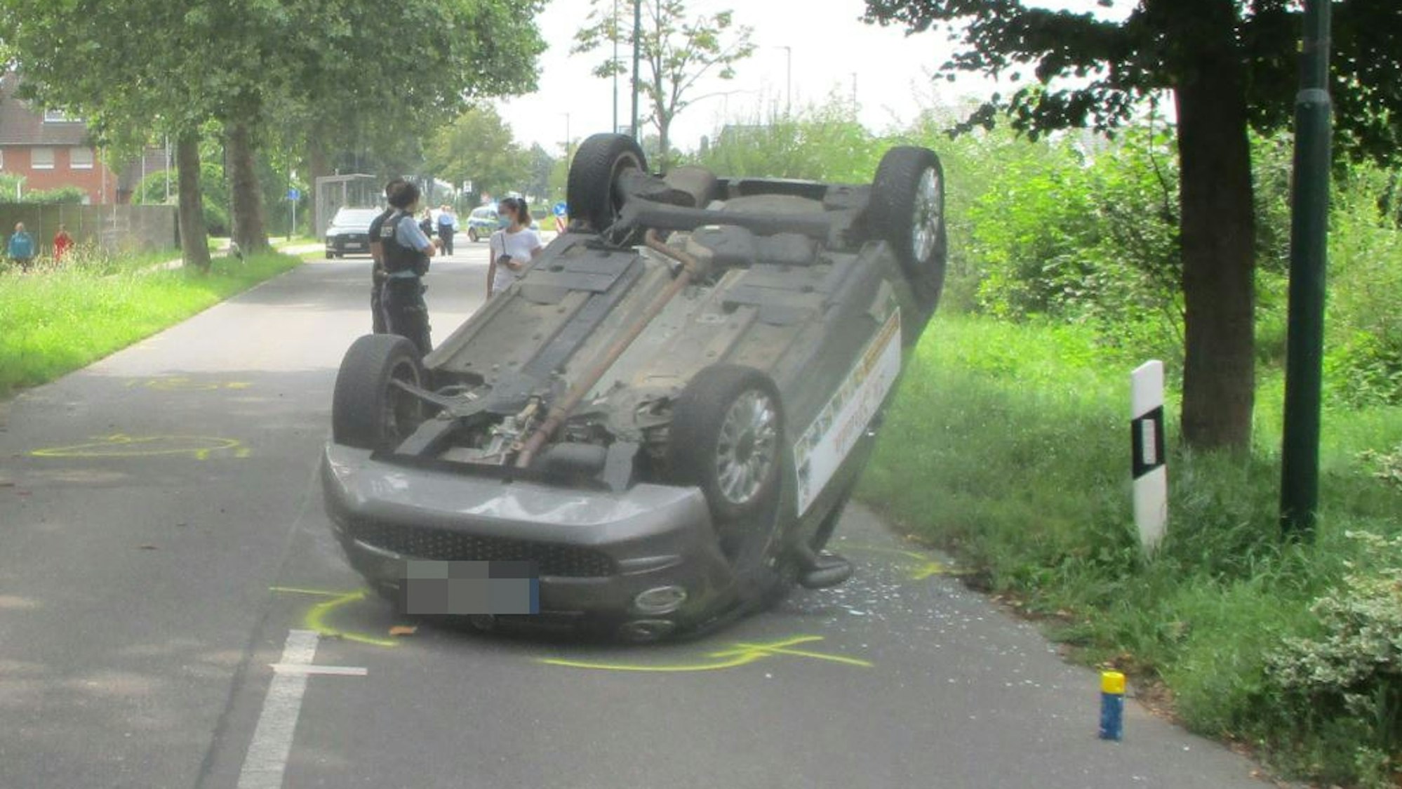Ein Auto hat sich auf einer Straße überschlagen und liegt auf dem Dach.