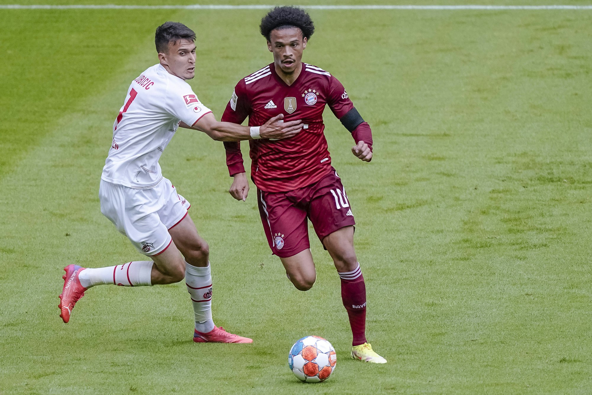 Leroy Sané und Köln Dejan Ljubicic jagen dem Ball hinterher.