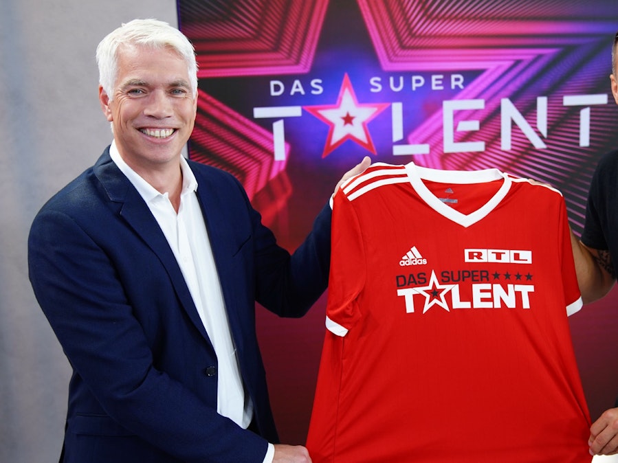 Die Freude war groß bei RTL Ende Juni, als klar war, dass Fußball-Weltmeister Lukas Podolski (r., hier zusammen mit Henning Tewes, Geschäftsführer RTL) Juror beim „Supertalent“ 2021 sein soll. Nach Podolskis positivem Corona-Test ist der weitere Plan für die Produktion nun aber offen.