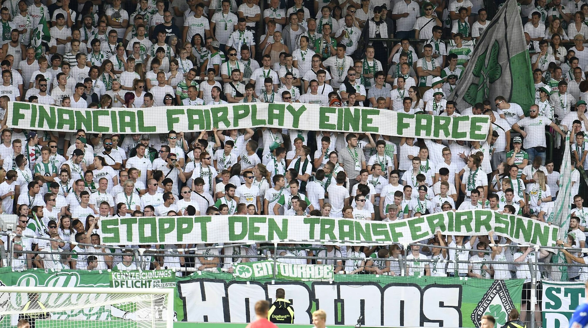 Fans von Greuther Fürth zeigen ein Banner mit dem Schriftzug „Financial Fairplay eine Farce, stoppt den Transferwahnsinn!“