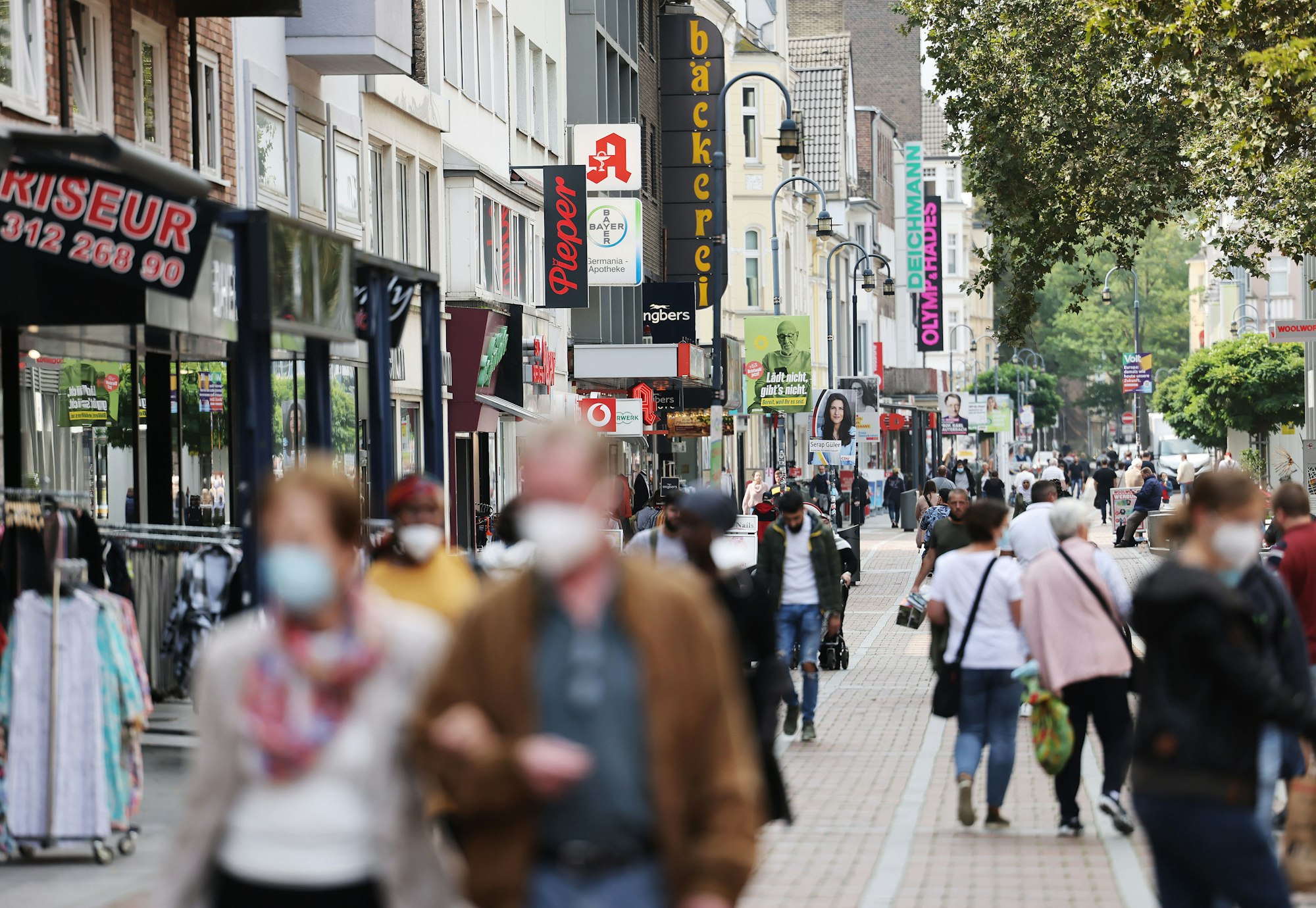 Menschen mit Maske gehen durch die Fußgängerzone in Leverkusen.