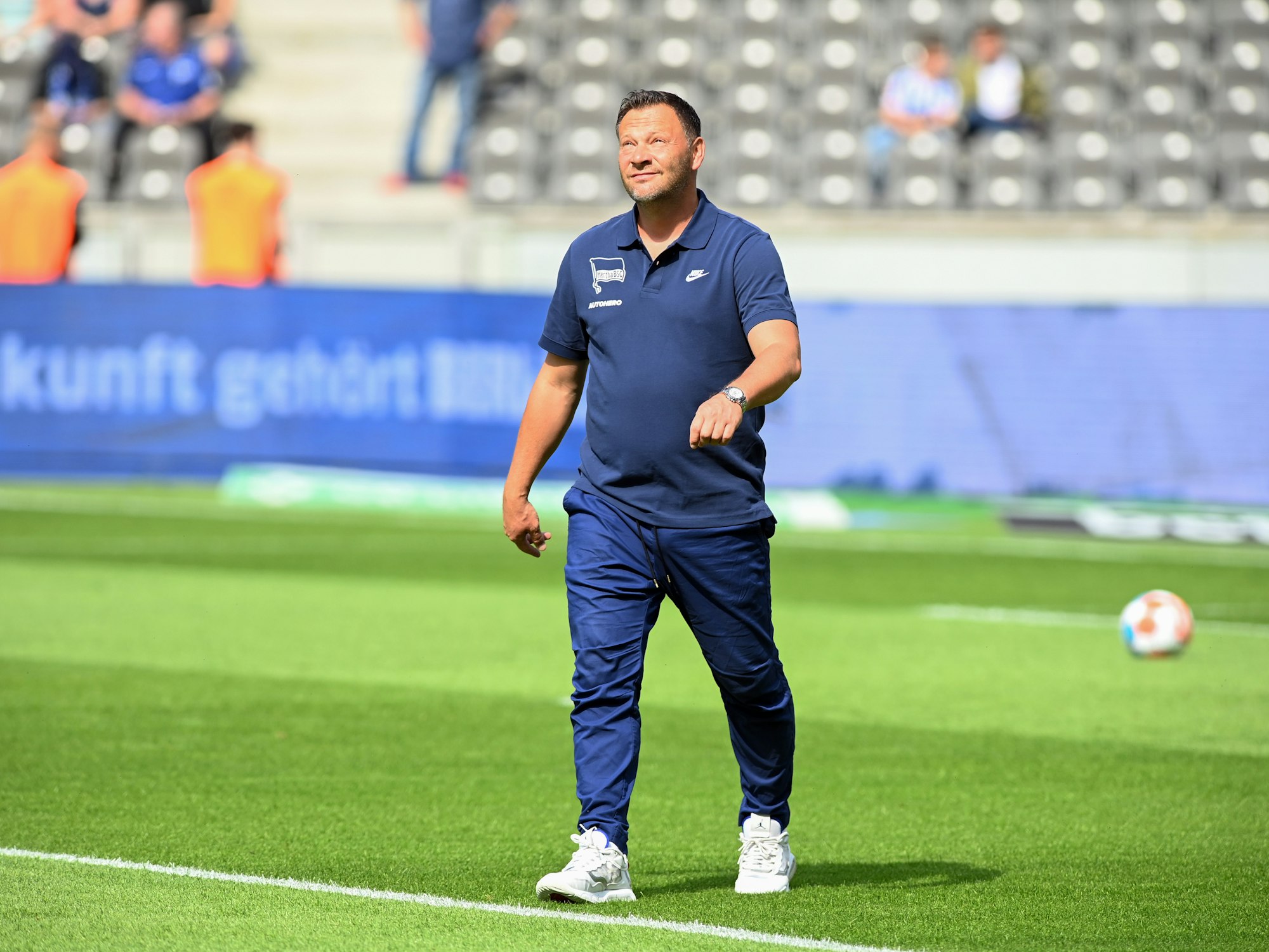 Cheftrainer Pal Dardai von Hertha BSC geht vor dem Spiel über den Rasen und blickt nach oben.