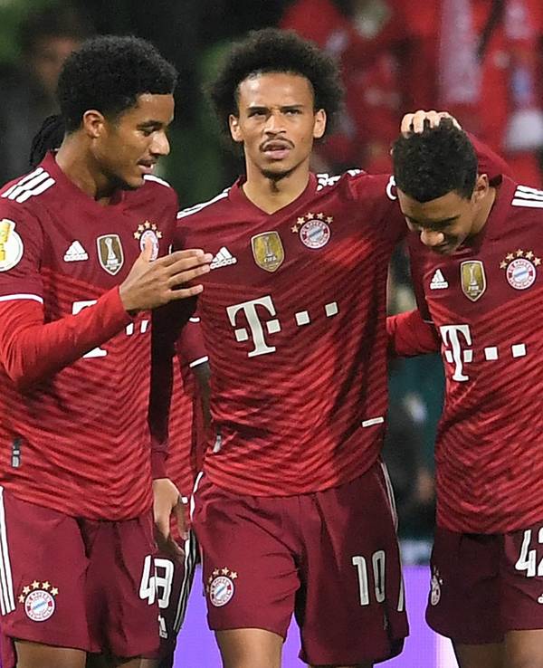 Bayerns Malik Tillmann (l) und Leroy Sane (M) freuen sich mit dem Torschützen zum 0:7 Jamal Musiala.