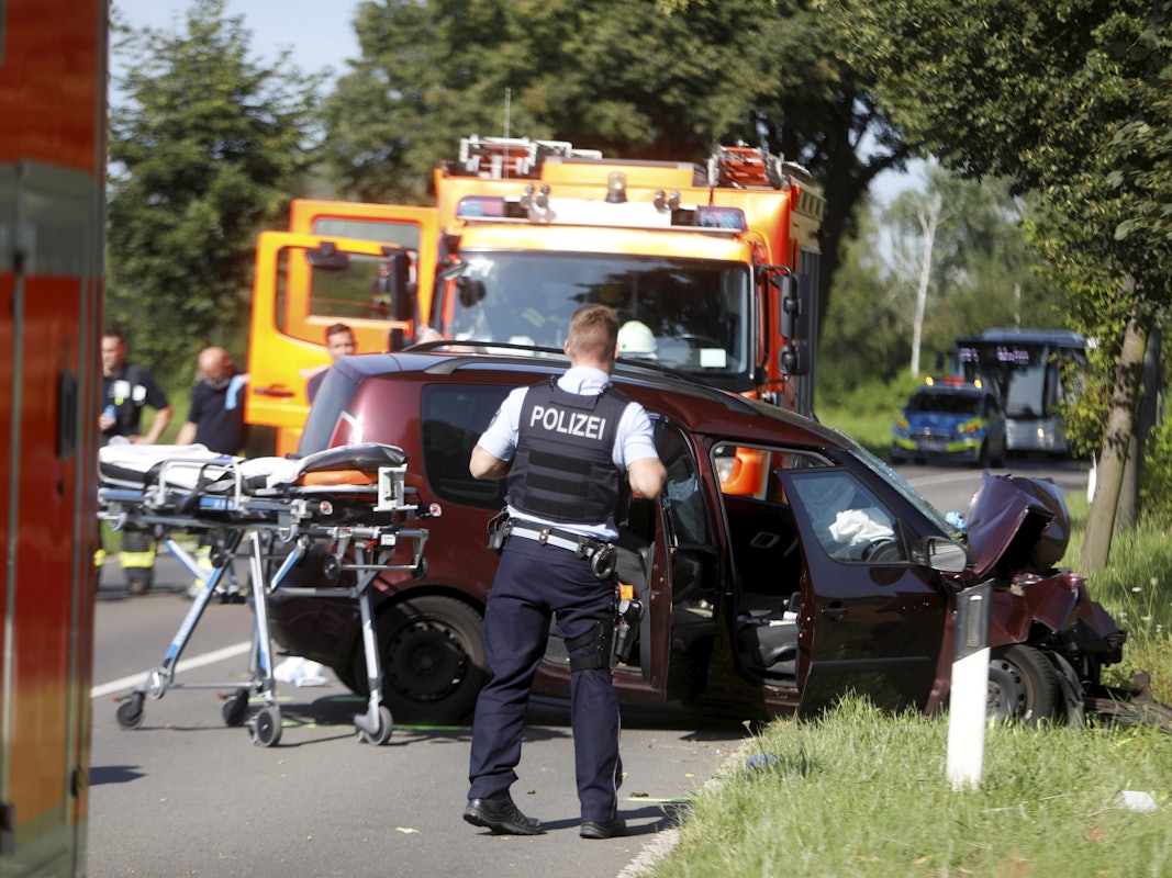 Ein Auto steht schwer beschädigt auf der Straße.