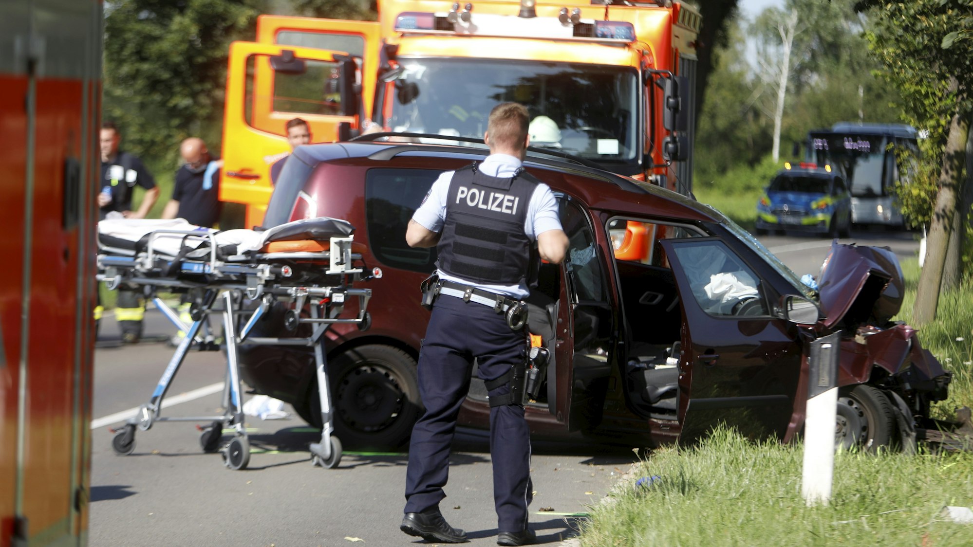 Ein Auto steht schwer beschädigt auf der Straße.