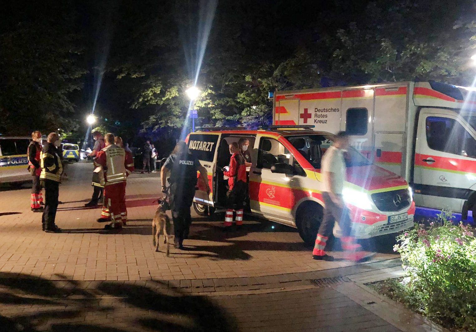 Helfer und Polizisten stehen in Groß-Gerau neben einem Krankenwagen und einem Notarztwagen. Dienstagnacht (24. August 2021) kam es in der hessischen Stadt zu einer Auseinandersetzung, bei der ein Mann von Polizisten erschossen wurde.