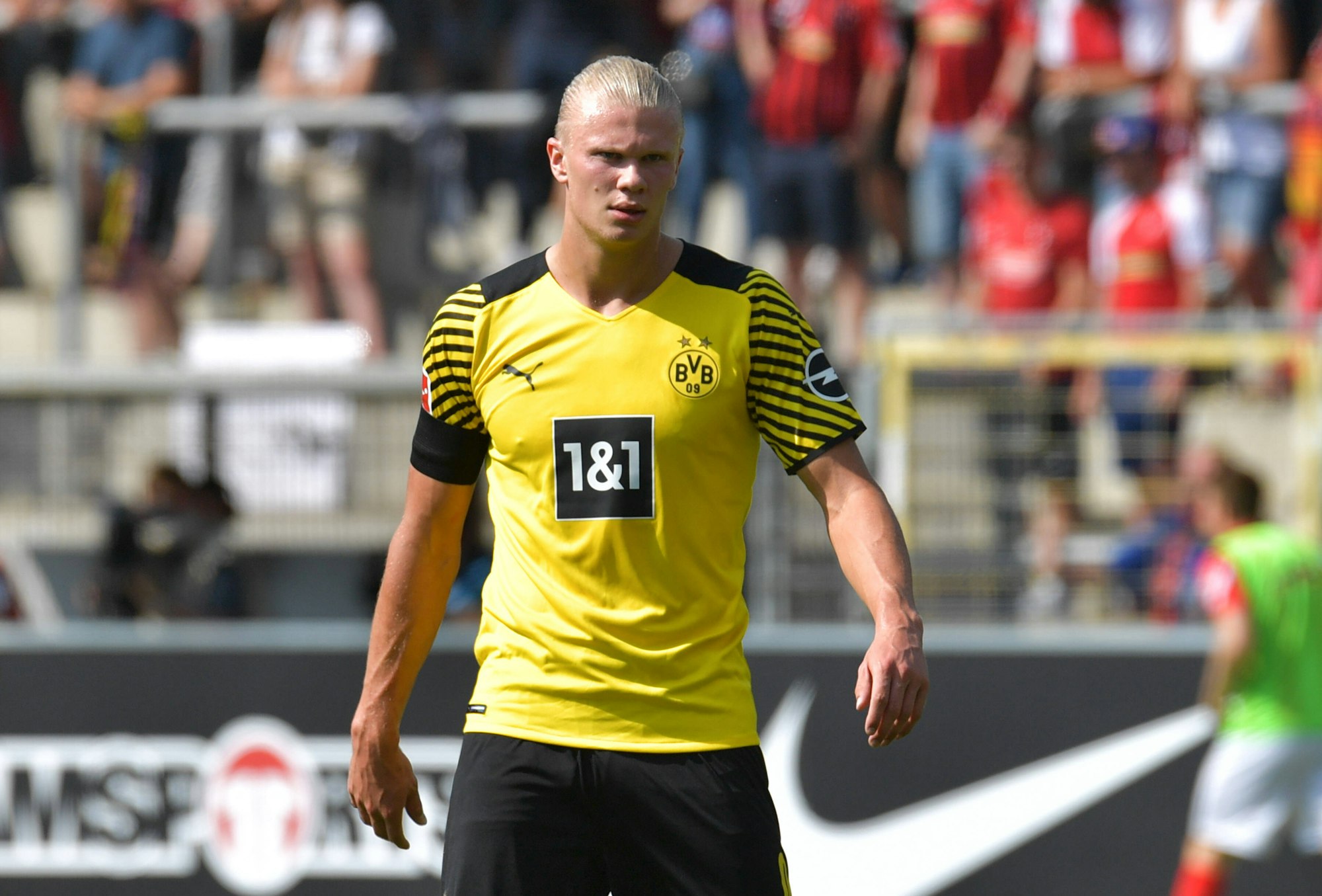 Erling Haaland läuft durch das Stadion des SC Freiburg und guckt grimmig.