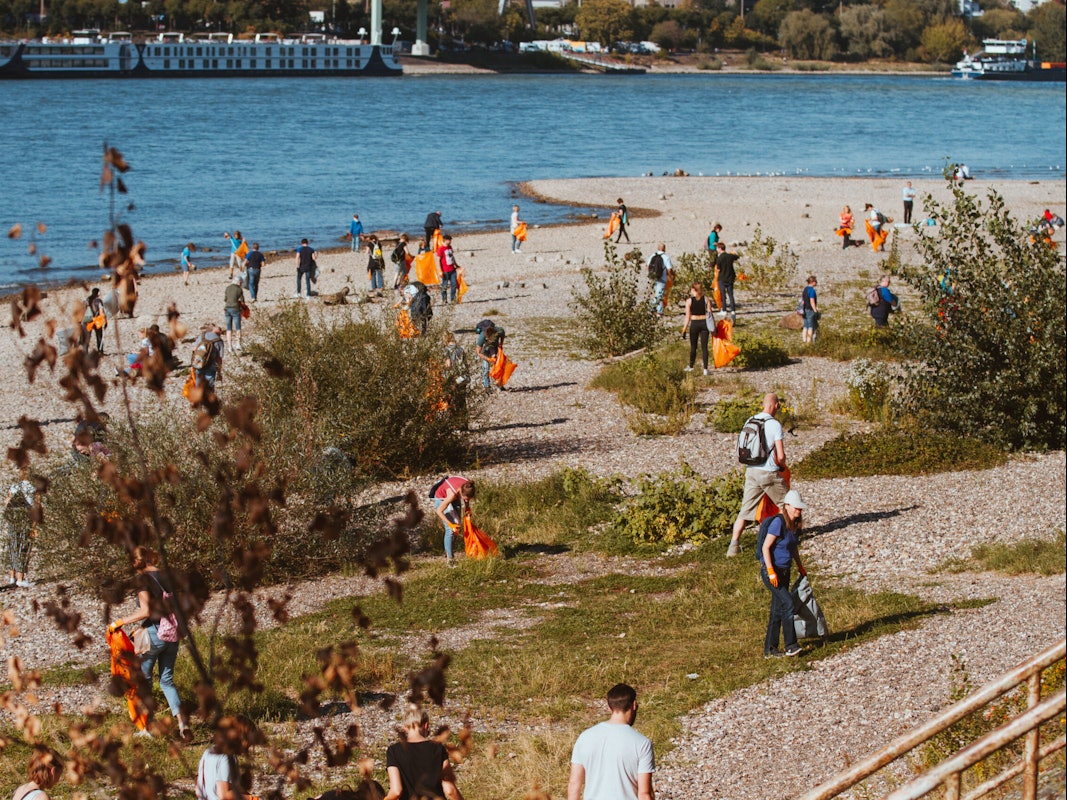 Mitglieder der Kölner-Rhein-Aufräum-Kommando-Einheit („K.R.A.K.E.“) sammeln am Deutzer Rheinufer Müll ein.