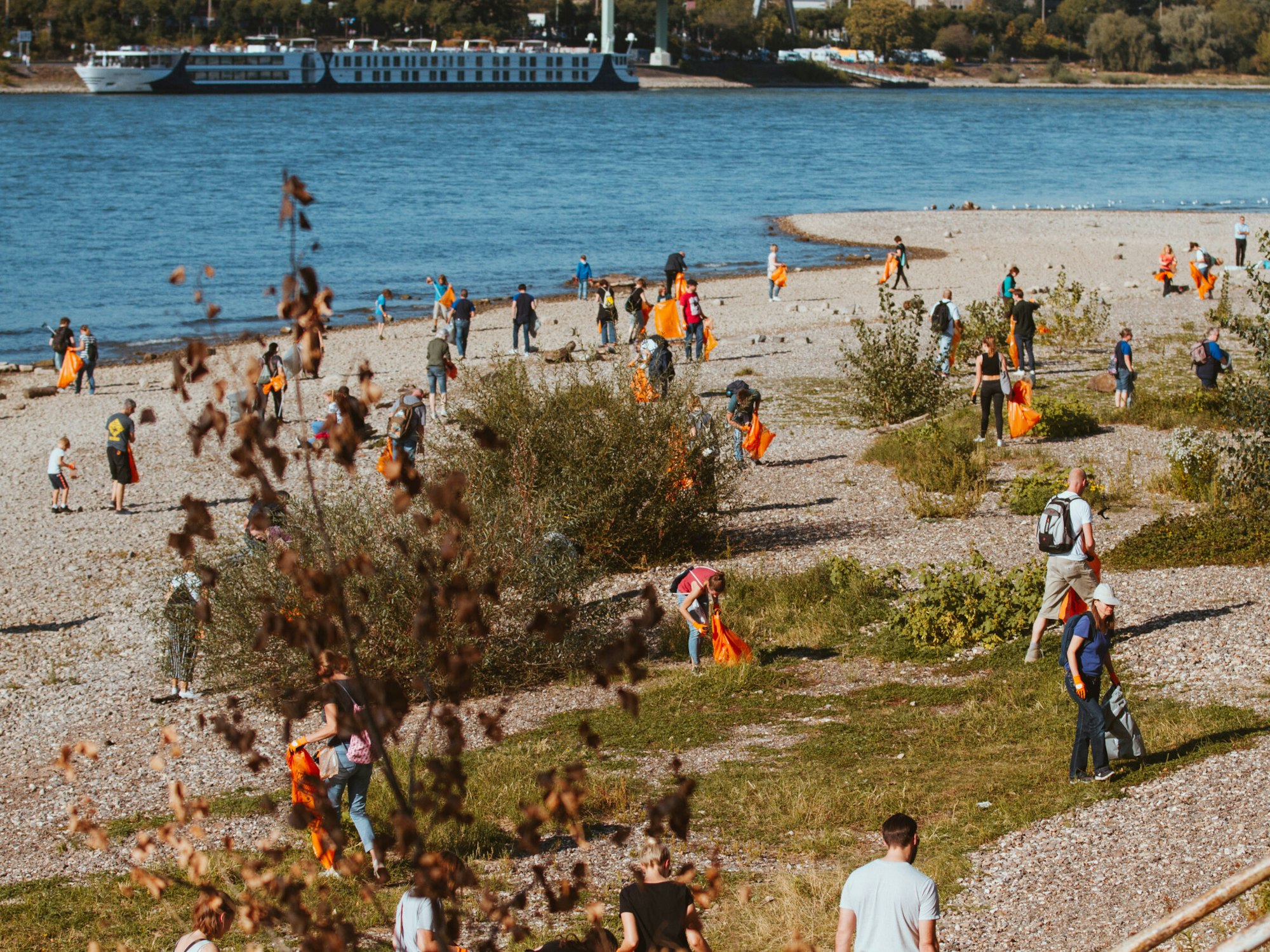 Mitglieder der Kölner-Rhein-Aufräum-Kommando-Einheit („K.R.A.K.E.“) sammeln am Deutzer Rheinufer Müll ein.