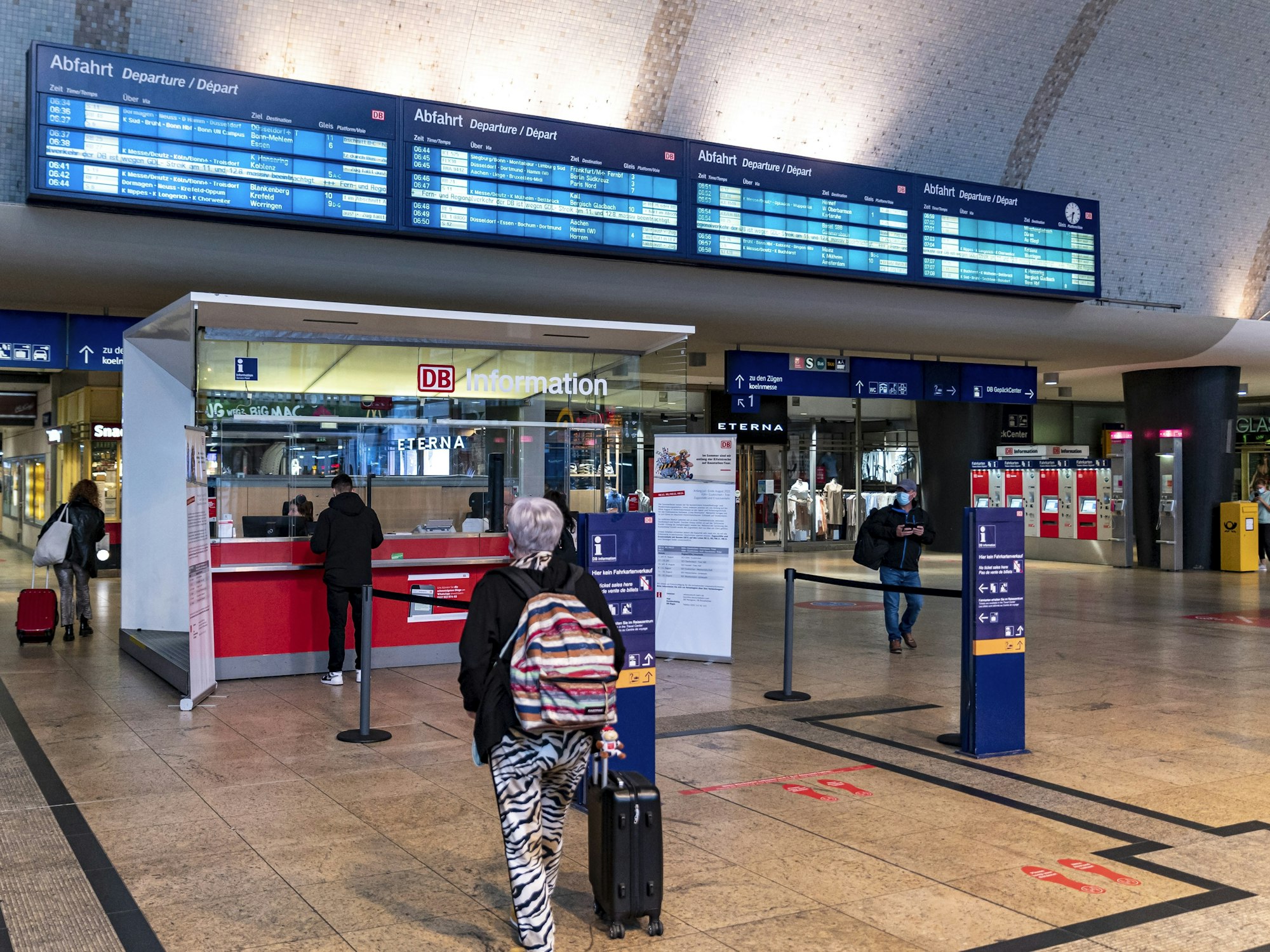Menschen am Infostand im Hauptbahnhof Köln.