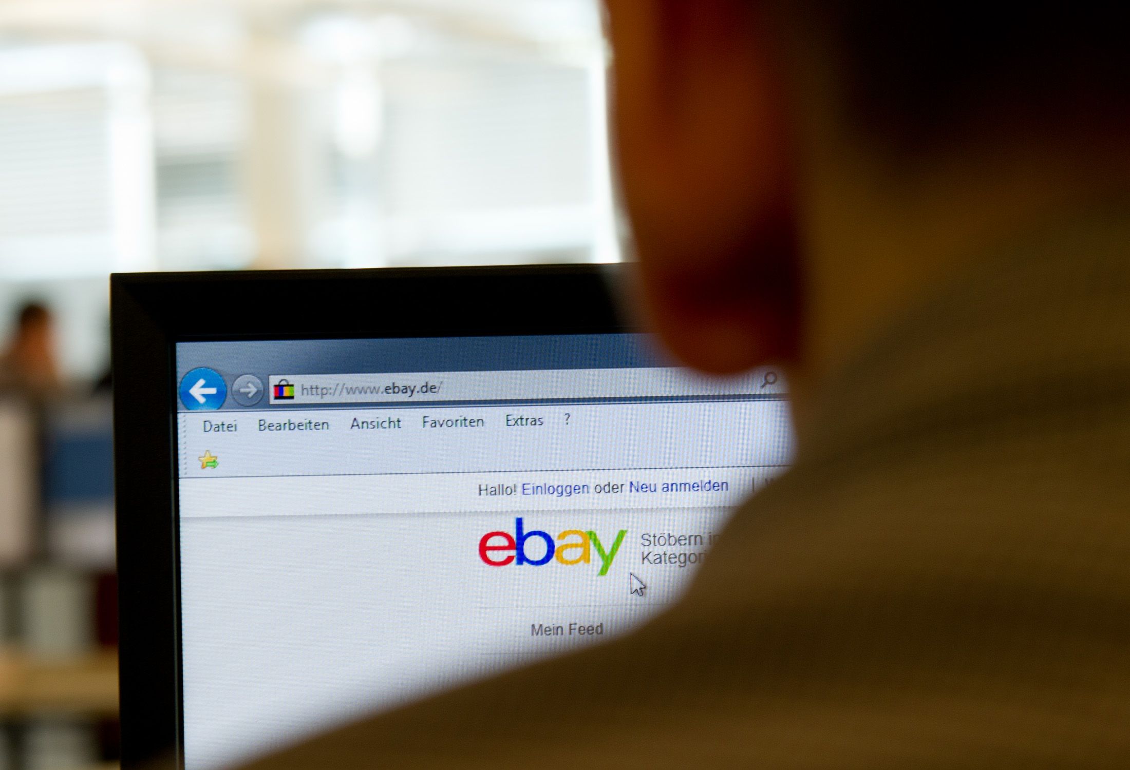 Mann kauft am PC bei Ebay ein.