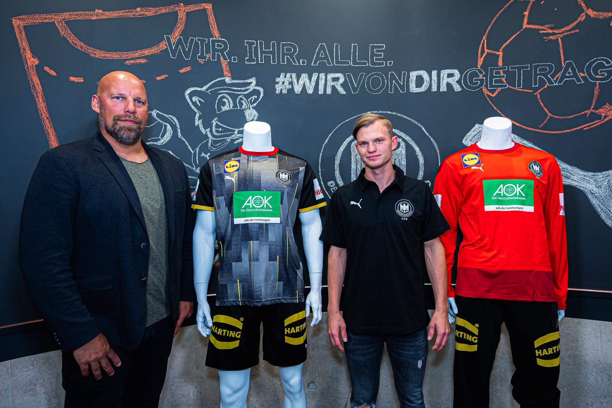 Der deutsche Nationalspieler Timo Kastening und DHB-Sportvorstand Axel Kromer stehen neben Modepuppen, die das neue Mannschafts- und Torwarttrikot tragen.
