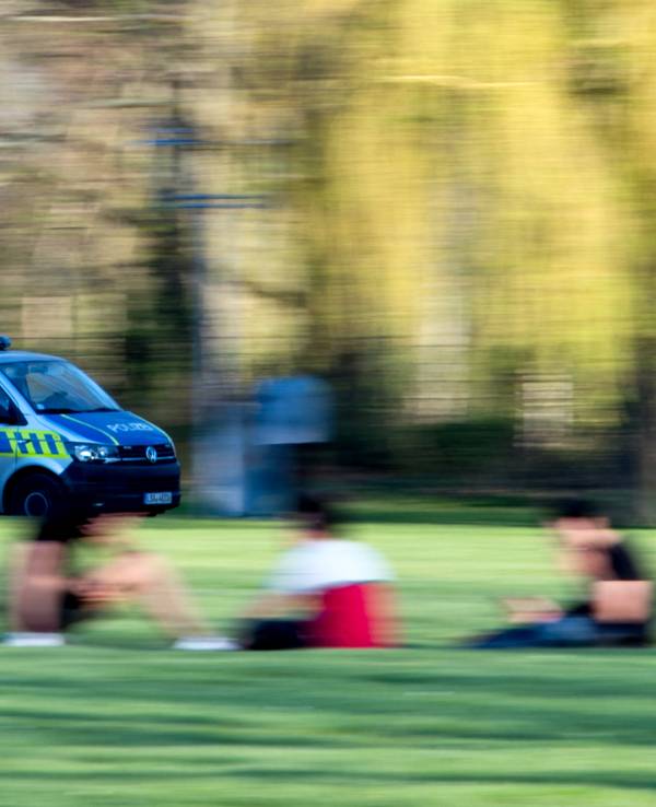 Ein Polizeifahrzeug fährt durch einen Park.