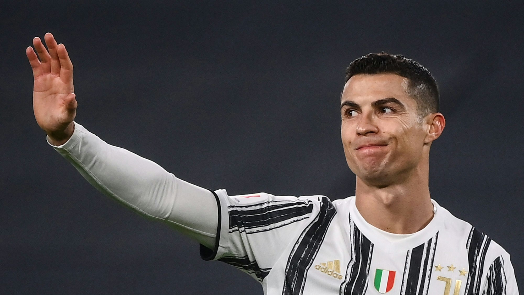 Cristiano Ronaldo hebt im Spiel für Juventus Turin entschuldigend die Hand.