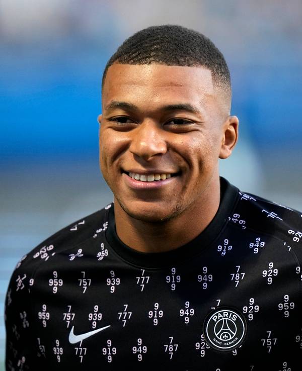 Kylian Mbappe von Paris lächelt beim Aufwärmen.