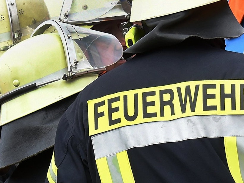 Der Schriftzug Feuerwehr steht während einer Rettungs-Übung an der Jacke eines Feuerwehrmannes.