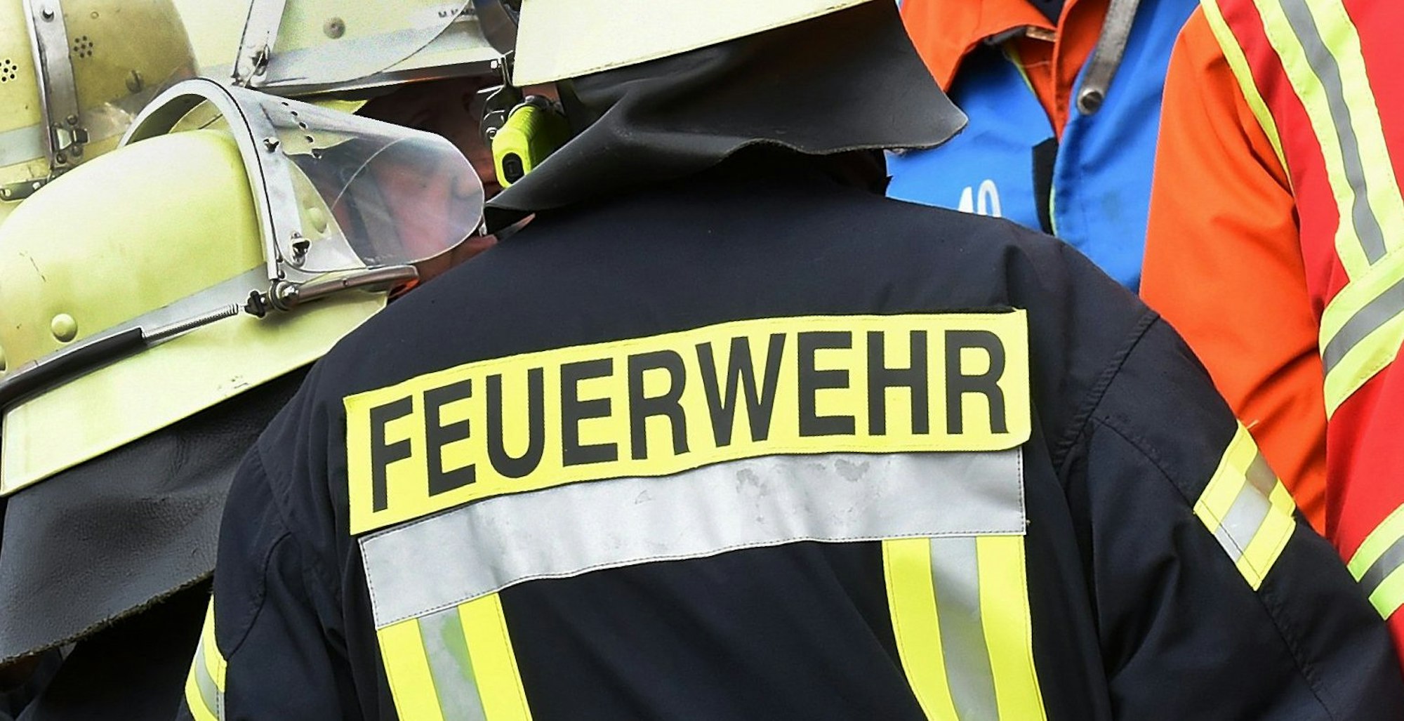 Der Schriftzug Feuerwehr steht während einer Rettungs-Übung an der Jacke eines Feuerwehrmannes, es handelt sich um ein Symbolfoto aus dem Jahr 2014