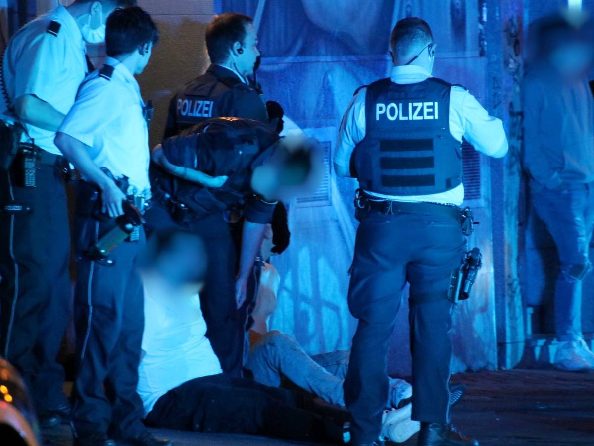 Polizisten stehen nachts am Zülpicher Platz und haben zwei Männer festgenommen.