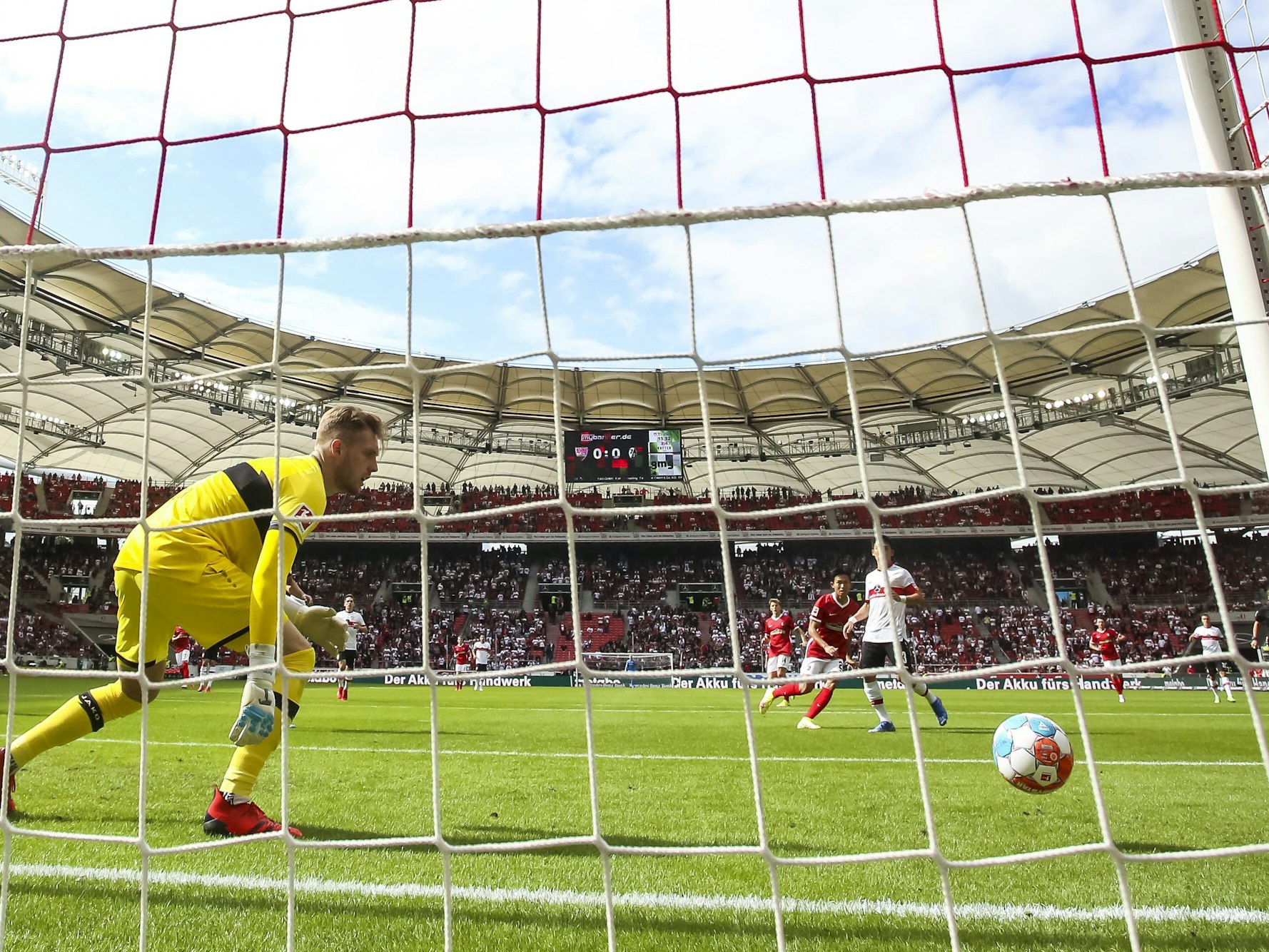 3. Spieltag in der Mercedes-Benz-Arena. Freiburgs Woo-yeong Jeong (2.v.r) trifft gegen Stuttgarts Torwart Florian Müller (l).