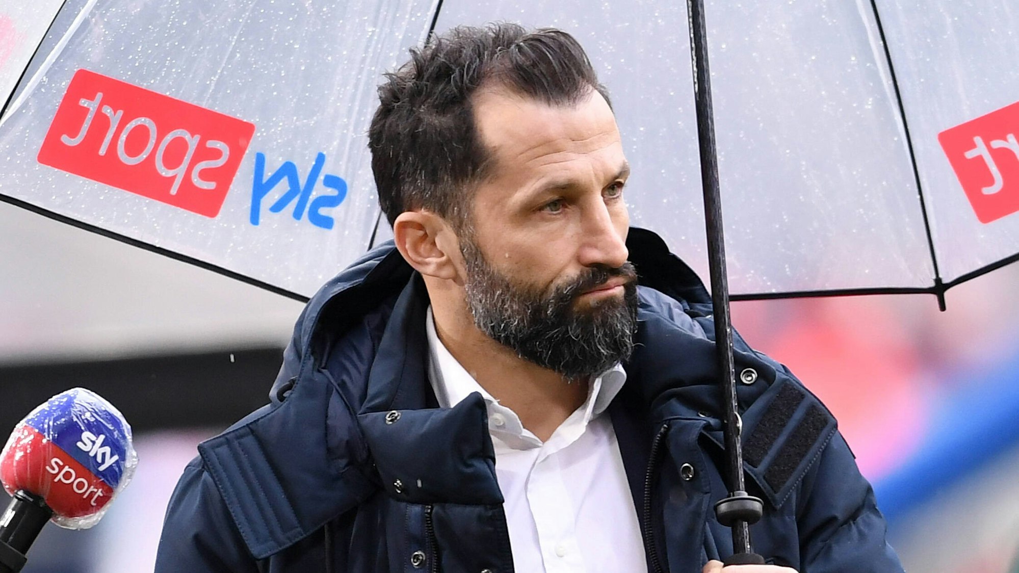 Sportdirektor Hasan Salihamidzic von Bayern München mit Sky Regenschirm.