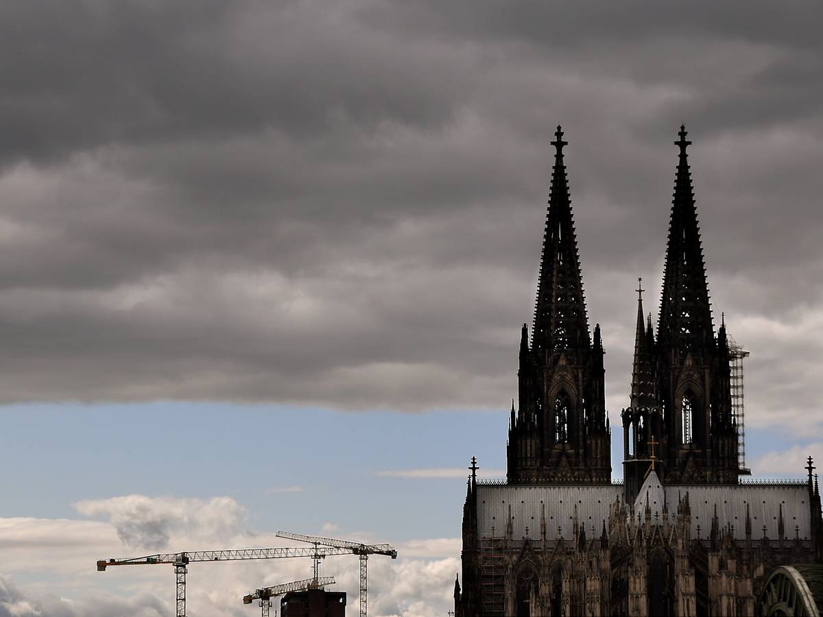 Der Kölner Dom mit seinen Turmspitzen kratzt an den dunklen Wolken.