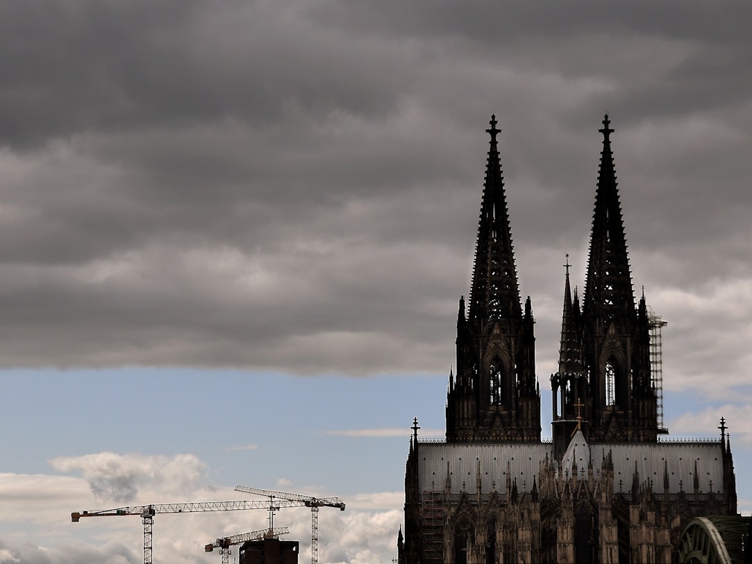 Der Kölner Dom mit seinen Turmspitzen kratzt an den dunklen Wolken.