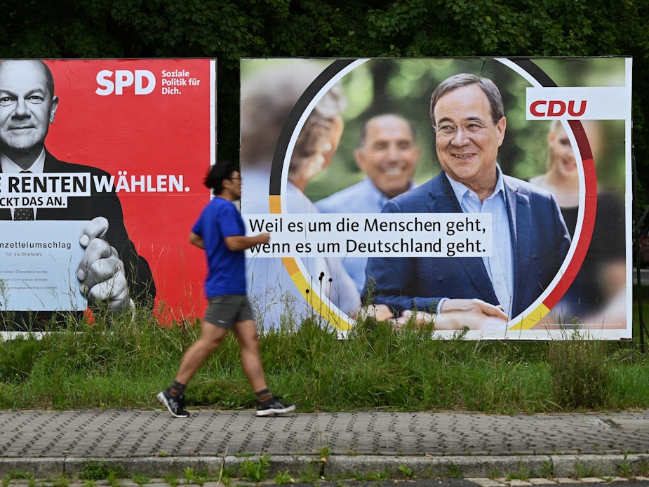 Ein Jogger läuft an großen Wahlplakaten mit den Spitzenkandidaten Olaf Scholz (SPD, l) und Armin Laschet (CDU) vorbei.