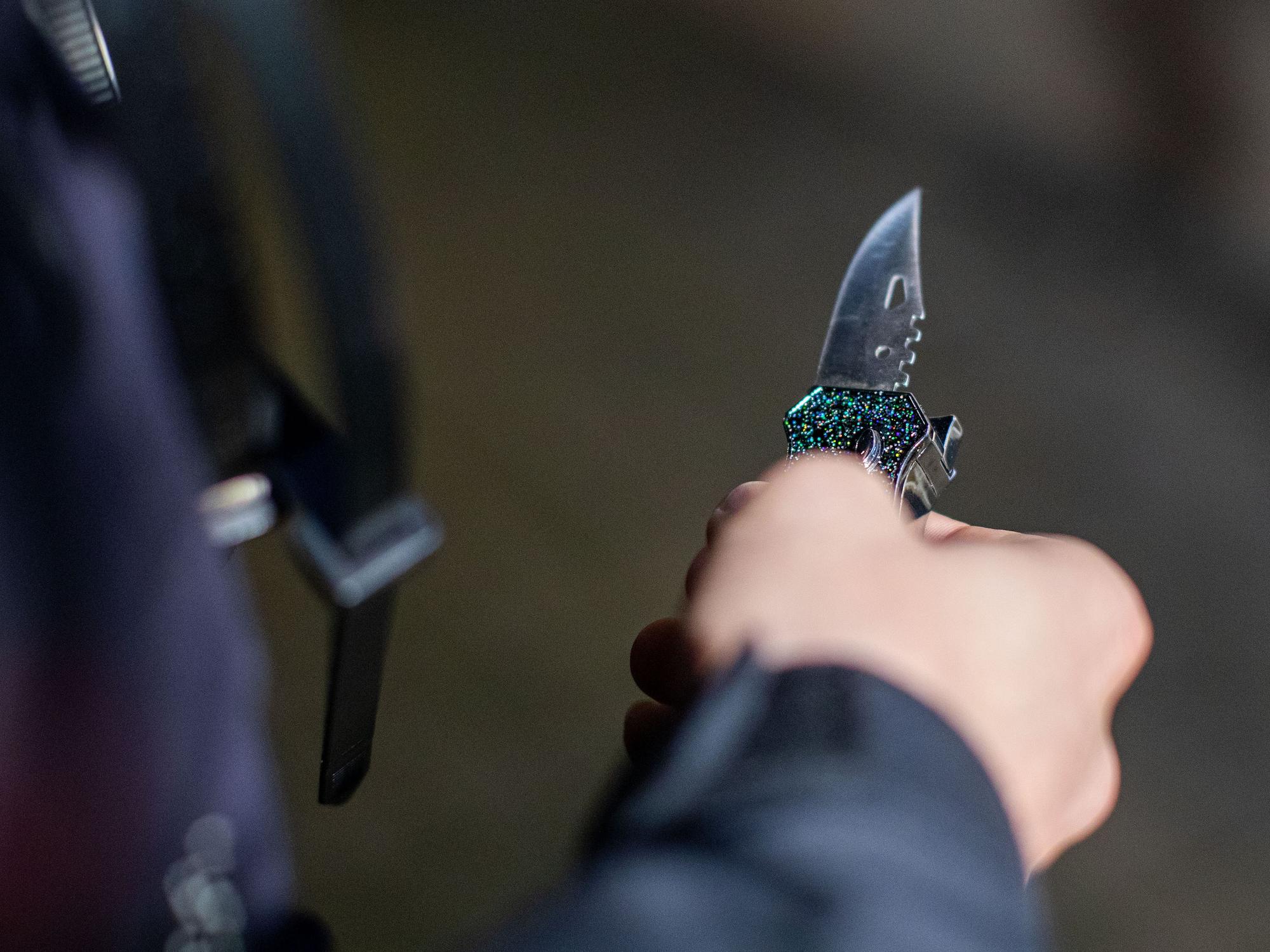 Ein Polizist hält ein sichergestelltes Messer in der Hand.