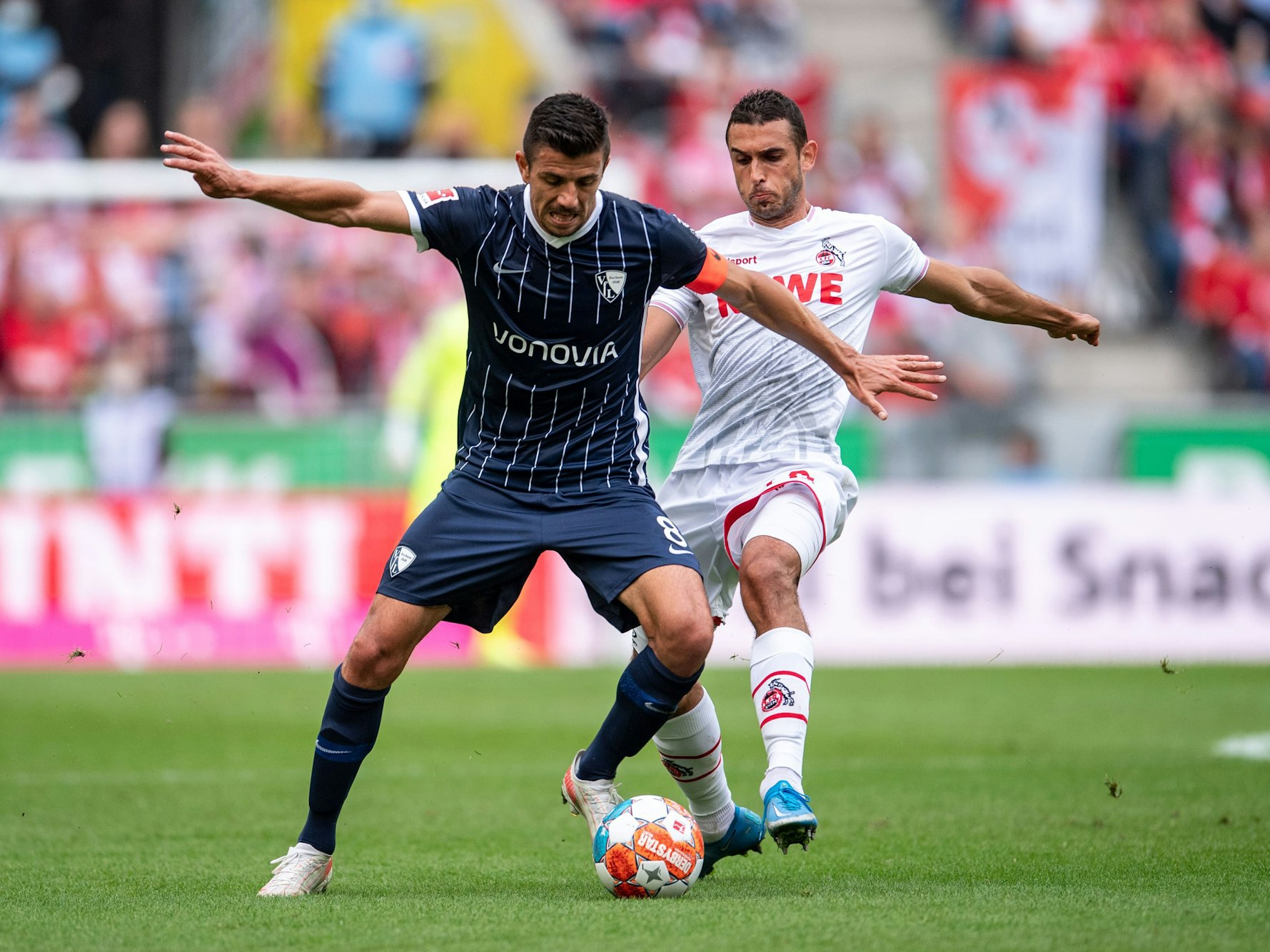 Kölns Ellyes Skhiri (r) und Bochums Anthony Losilla kämpfen um den Ball.