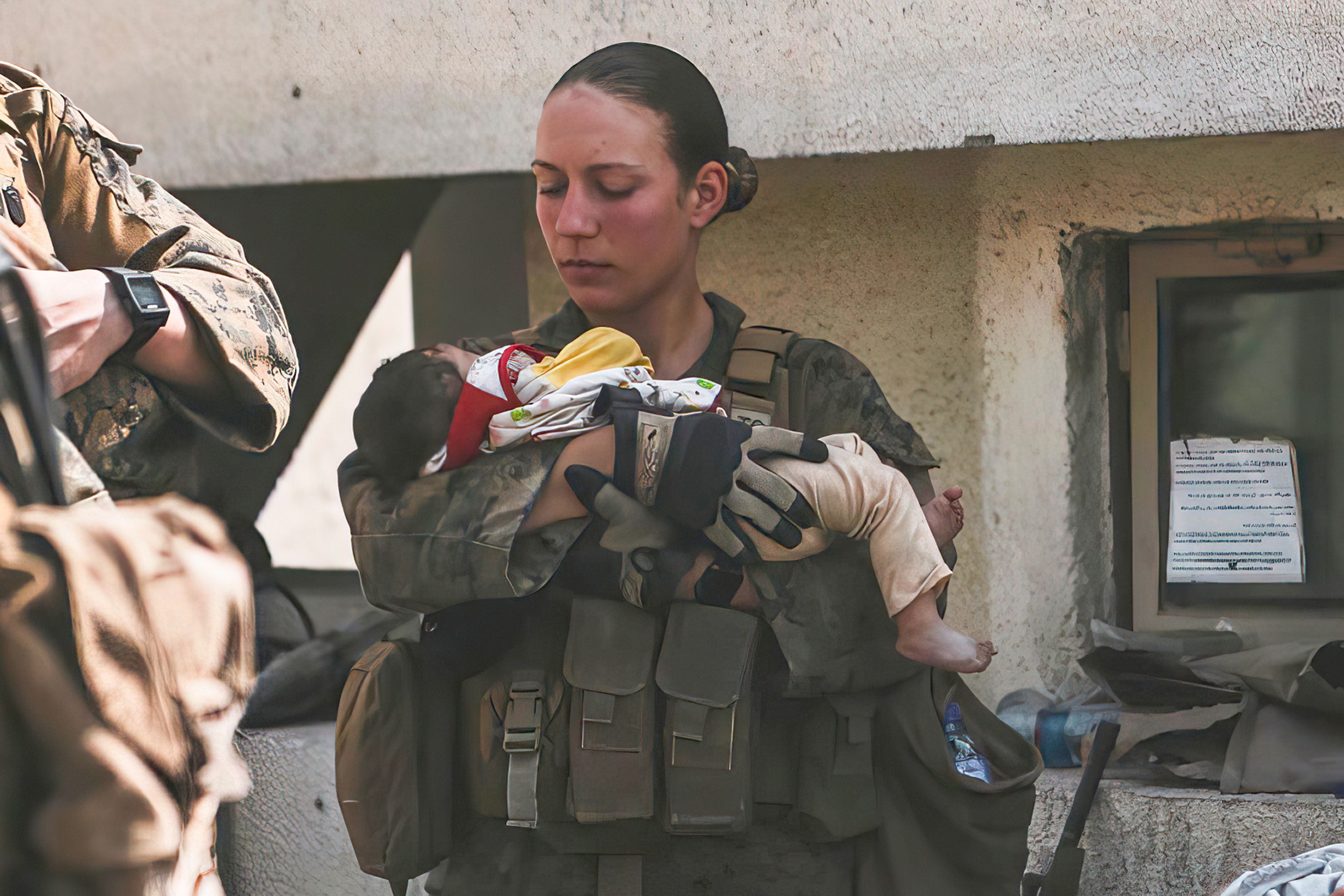 In diesem Bild vom 20. August 2021, das vom US Marine Corps zur Verfügung gestellt wurde, beruhigen Marines der 24. Marine Expeditionary Unit (MEU), darunter Sgt. Nicole Gee (links stehend) Kleinkinder während einer Evakuierung am Hamid Karzai International Airport in Kabul, Afghanistan.