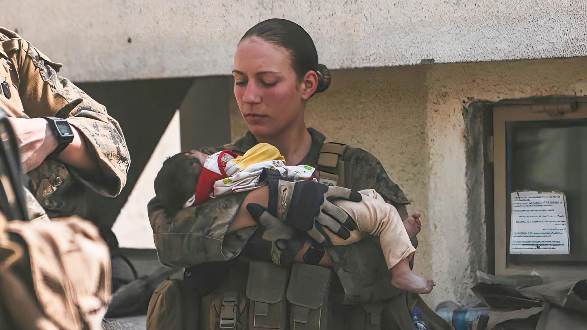 In diesem Bild vom 20. August 2021, das vom US Marine Corps zur Verfügung gestellt wurde, beruhigen Marines der 24. Marine Expeditionary Unit (MEU), darunter Sgt. Nicole Gee (links stehend) Kleinkinder während einer Evakuierung am Hamid Karzai International Airport in Kabul, Afghanistan.