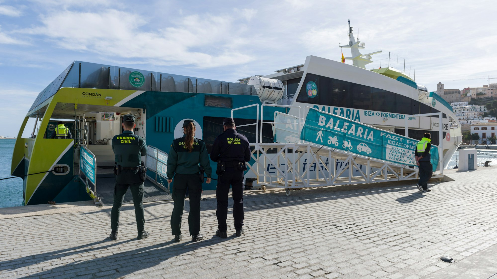 Zivilgardisten und ein Polizist stehen im Januar 2021 vor einem Schiff im Hafen von Ibiza.